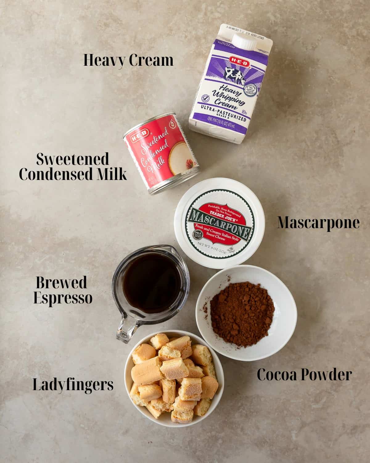 Gather sweetened condensed milk, mascarpone cheese, cocoa powder, heavy cream, espresso or coffee and ladyfingers.