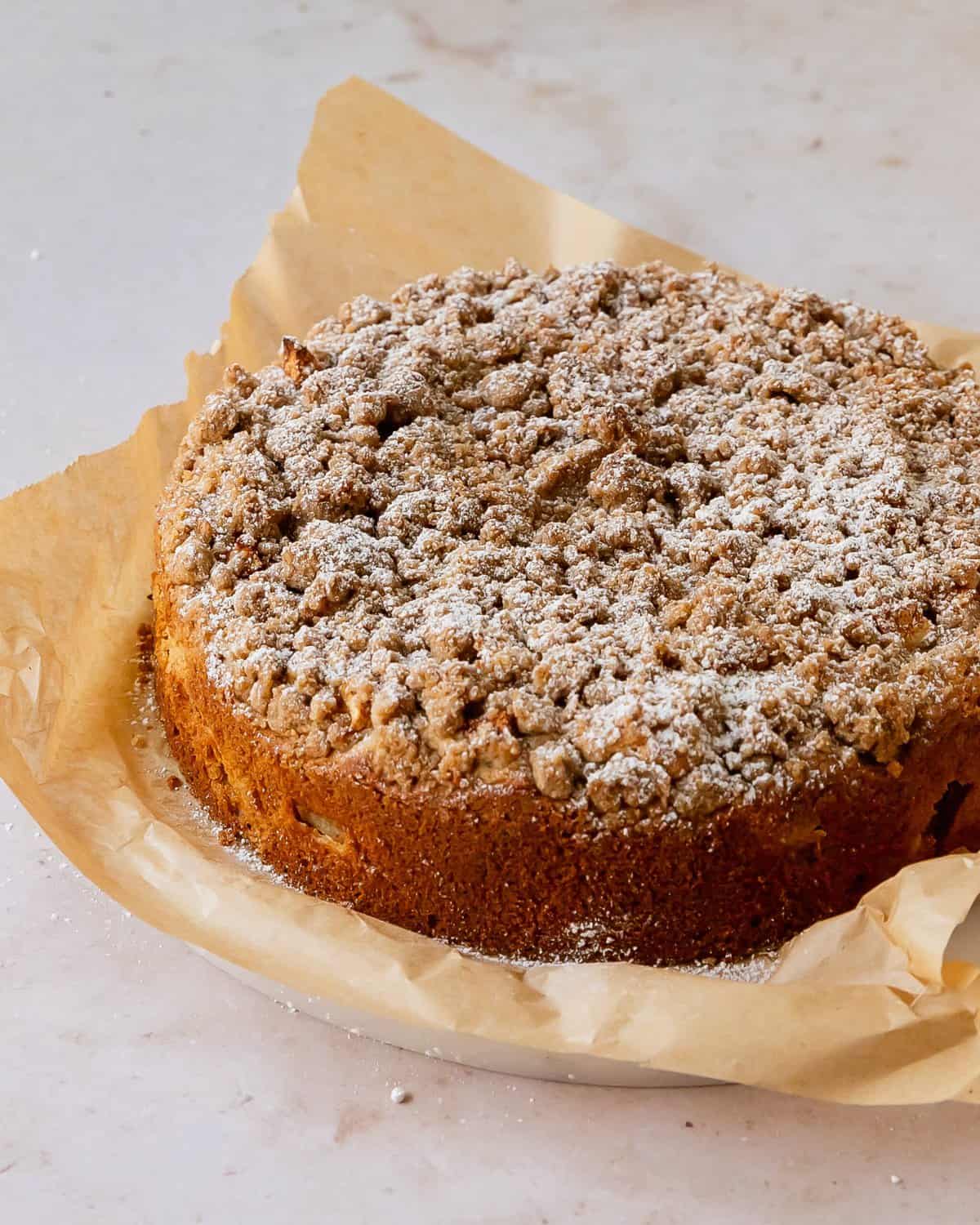 Apple crumble cake is a moist and buttery cinnamon and vanilla crumb cake filled with chunks of sweet and tart apples. It’s topped with a crunchy cinnamon spiced crumble that is the perfect complement to the cozy cinnamon spiced apples. Make this apple coffee cream coffee cake for a wonderfully delicious fall breakfast or dessert. 