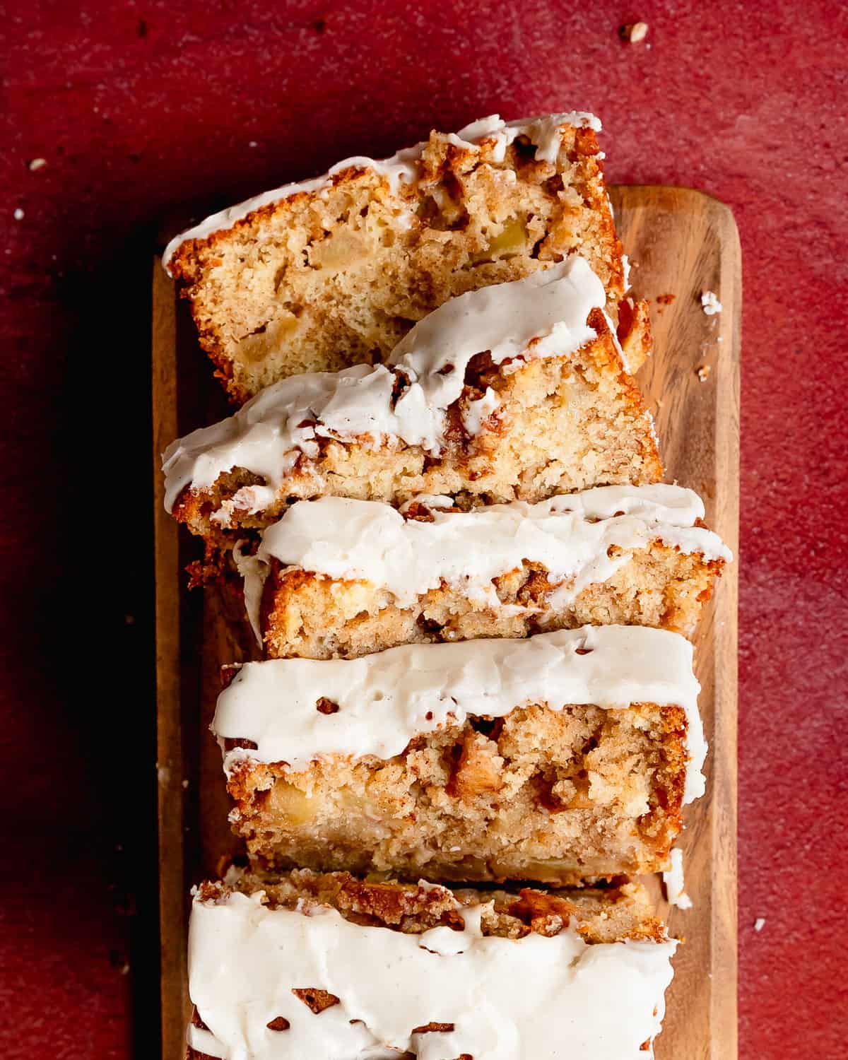 Apple fritter bread is a soft, moist and flavor packed apple quick bread with brown sugar cinnamon apples swirled throughout. The spiced apple fritter topping is also swirled on the apple bread giving you cozy, caramelized apple chunks in every bite. Make this Amish apple bread truly decadent by topping it with an easy vanilla bean glaze. 