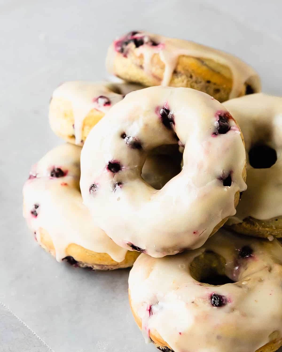 These blueberry donuts soft and fluffy cake donuts filled with fresh or frozen blueberries topped with a sweet and tart lemon glaze. The next time you want a fresh but cozy breakfast treat, grab your donut pan, a couple of mixing bowls, a whisk and make the best blueberry cake donuts. 