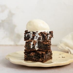 Brownies from Cake Mix Recipe Card Image. Brownie square stacked on a plate with ice cream.