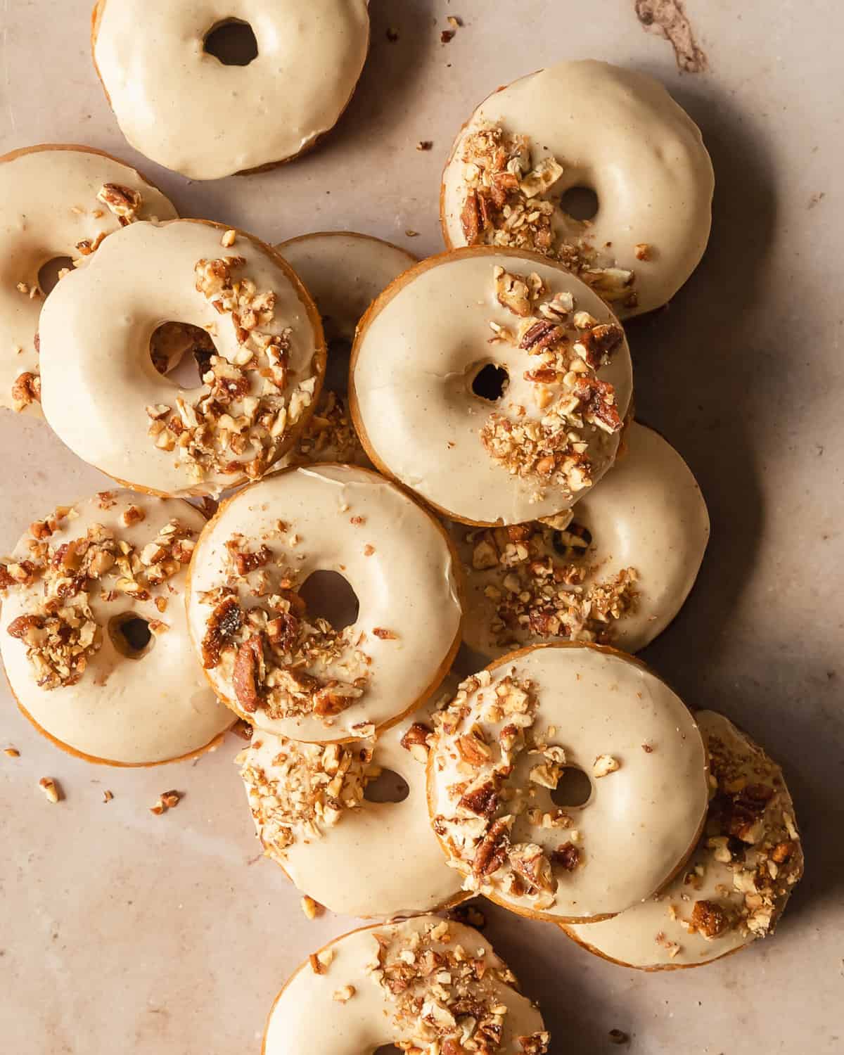 Maple glazed donuts with chopped pecans on top.