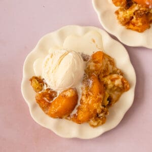 Peach Cobbler with Cake Mix Recipe Card image with peach cobbler on a plate topped with ice cream.