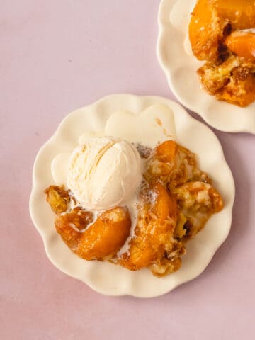 Peach Cobbler with Cake Mix on a plate with melting ice cream.