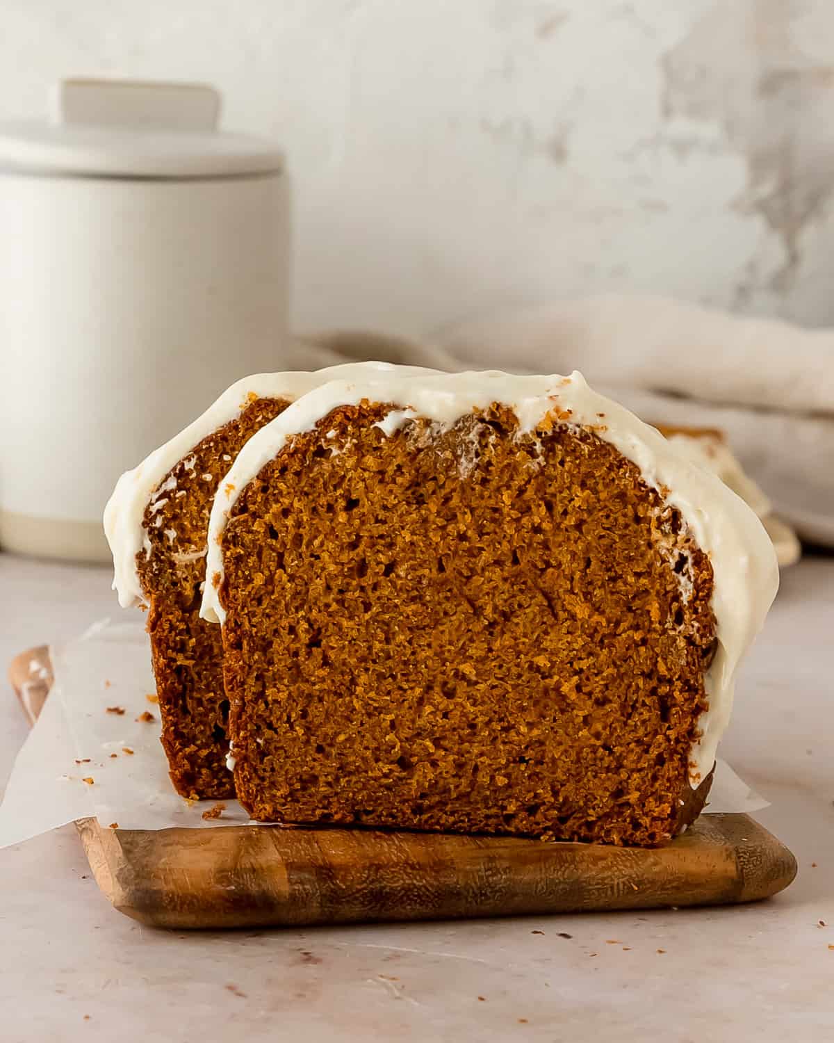 Pumpkin Bread with Cream Cheese Frosting with icing dripping down the side.