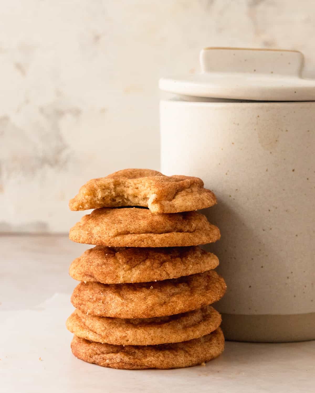 Snickerdoodles in a stack with one on top that has a bite taken out.