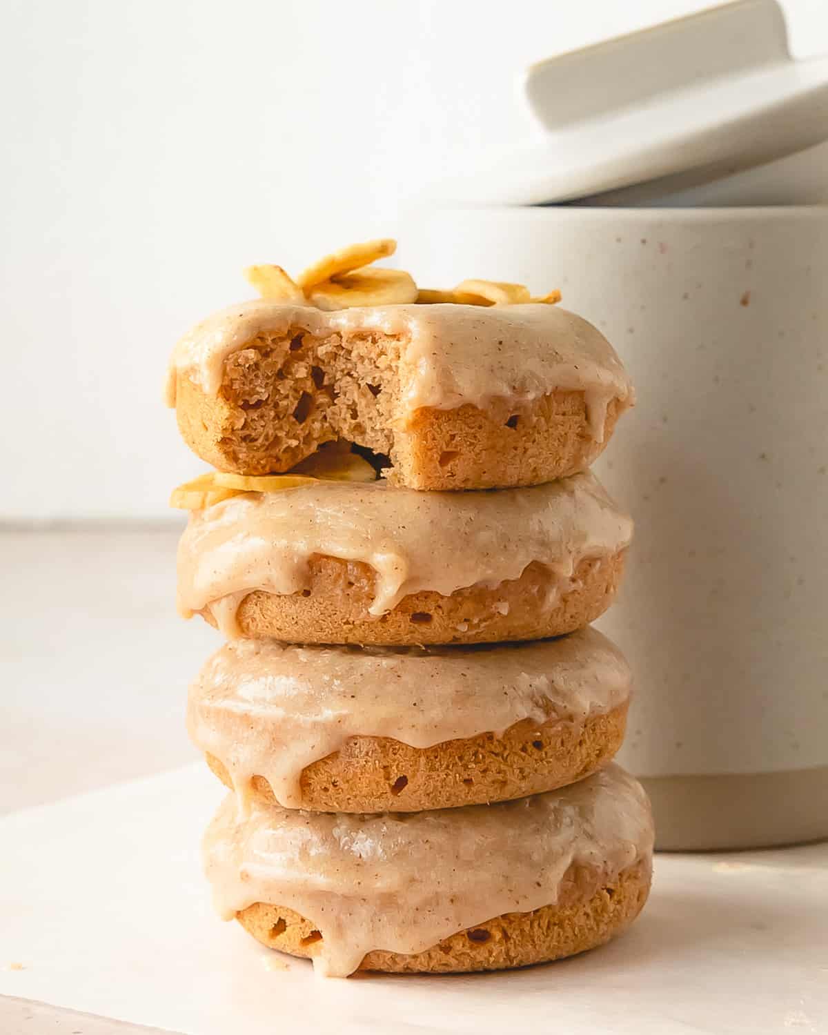 Banana Donuts with brown butter glaze in a stack.