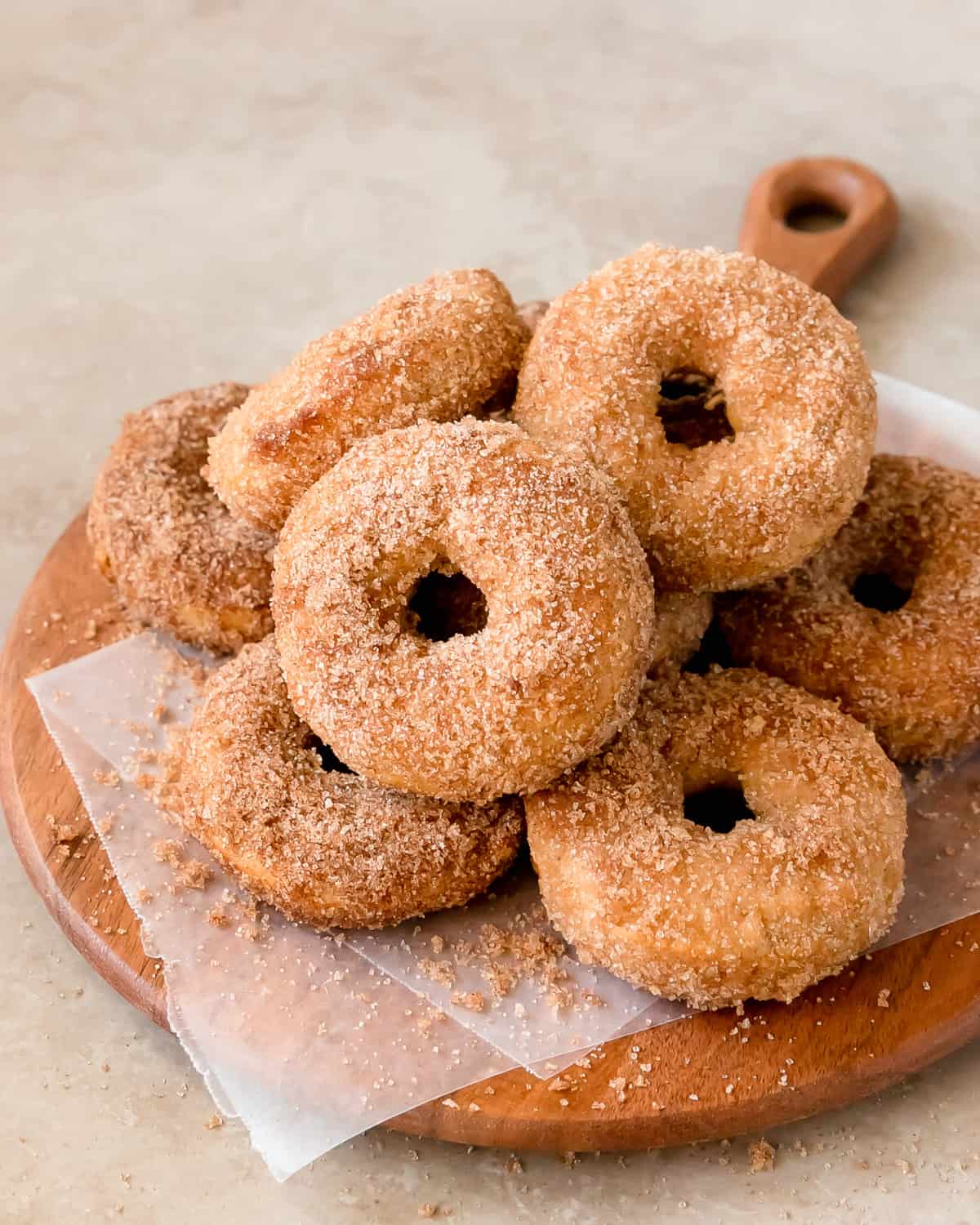 Baked donuts coated in cinnamon sugar on a serving plate