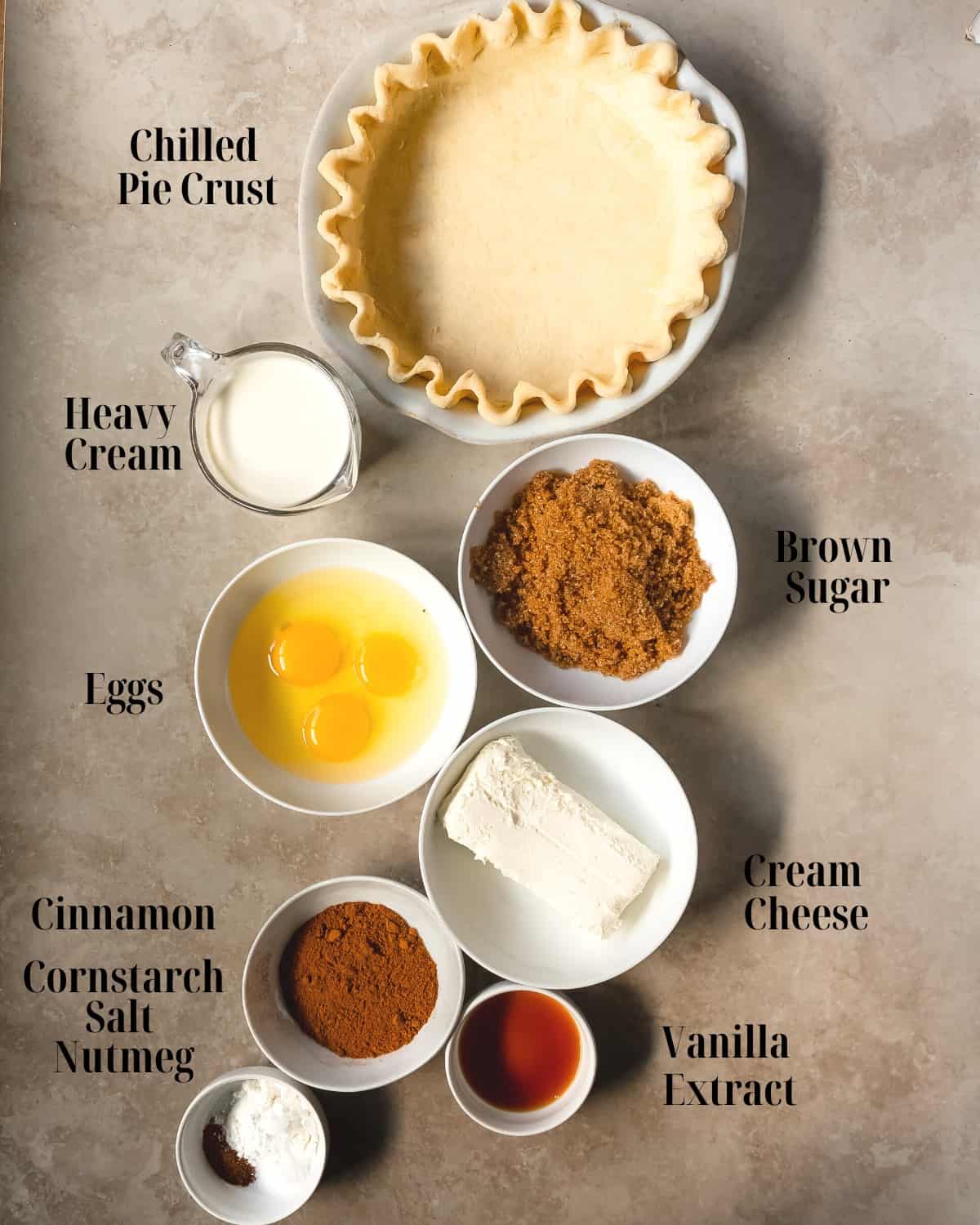 Gather a premade pie crust, cream cheese, brown sugar, eggs, vanilla extract, cinnamon, nutmeg, cornstarch, salt and heavy cream. 