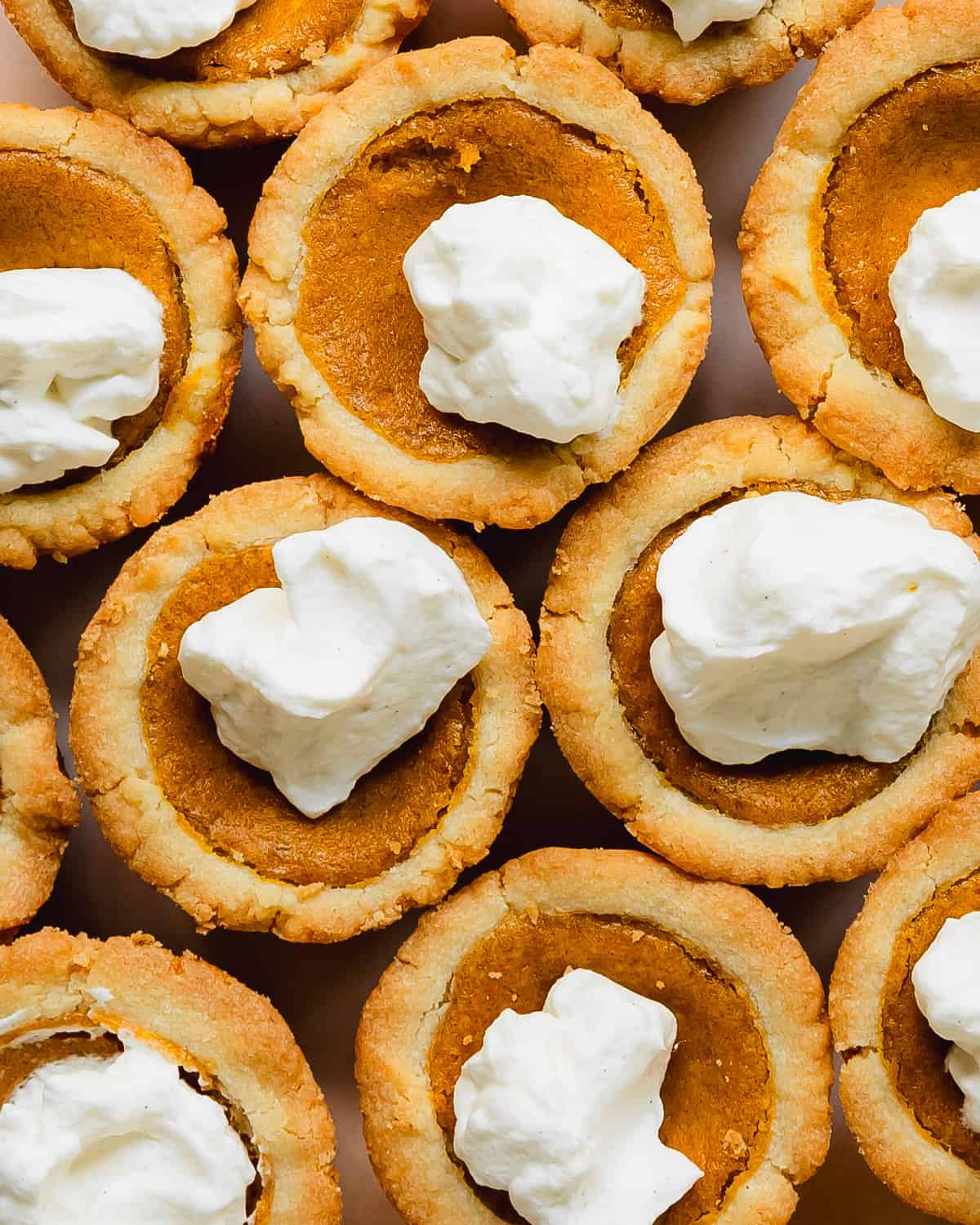 Pumpkin pie cookies are deliciously soft and buttery sugar cookie cups filled with a classic pumpkin pie filling.  This recipe for pumpkin pie cookies are easy to make, require no chilling time and are ready in about 30 minutes. These mini pumpkin cookies are a fun twist on the classic pumpkin pie dessert everyone will love.