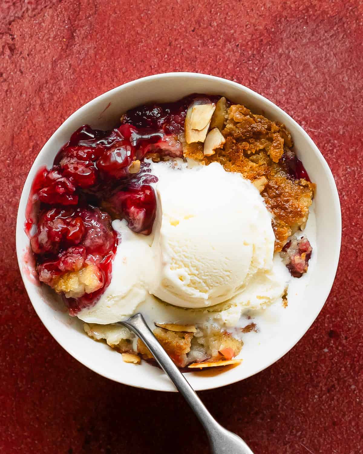 Cherry dump cake is an easy to make cherry cobbler with cake mix dessert. This recipe for cherry dump cake comes together quickly with pantry basics such as cake mix, cherry pie filling, canned or fresh cherries and butter. Top this cherry cobbler dump cake with vanilla ice cream for the perfect easy baked dessert. 