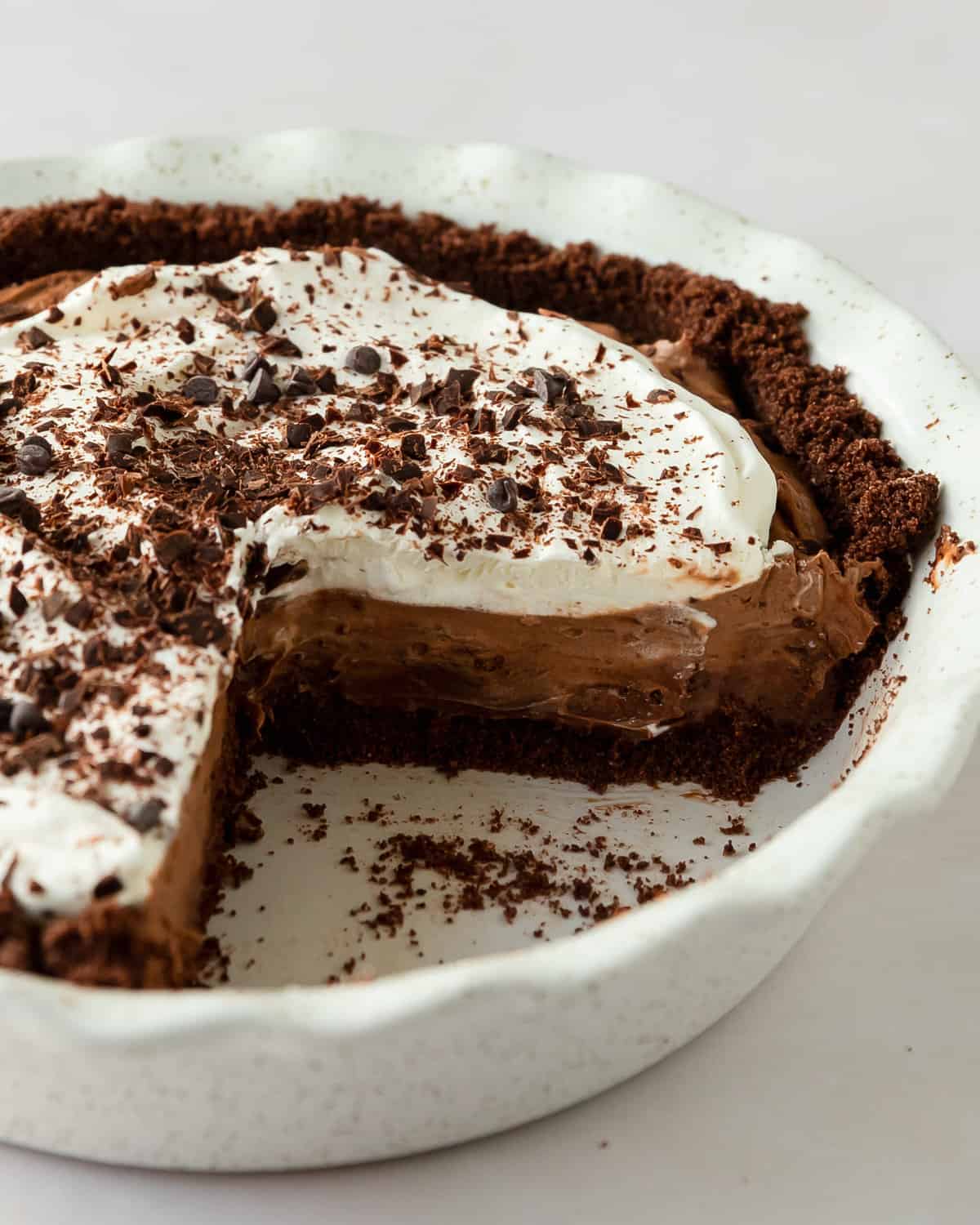 Chocolate pudding pie is a no bake pie made with a chocolate cookie crust topped with a creamy instant chocolate pudding filling, lightly sweetened whipped cream and chocolate shavings. Enjoy this jello pudding pie the next time you need a deliciously decadent, quick and easy dessert everyone will love. 