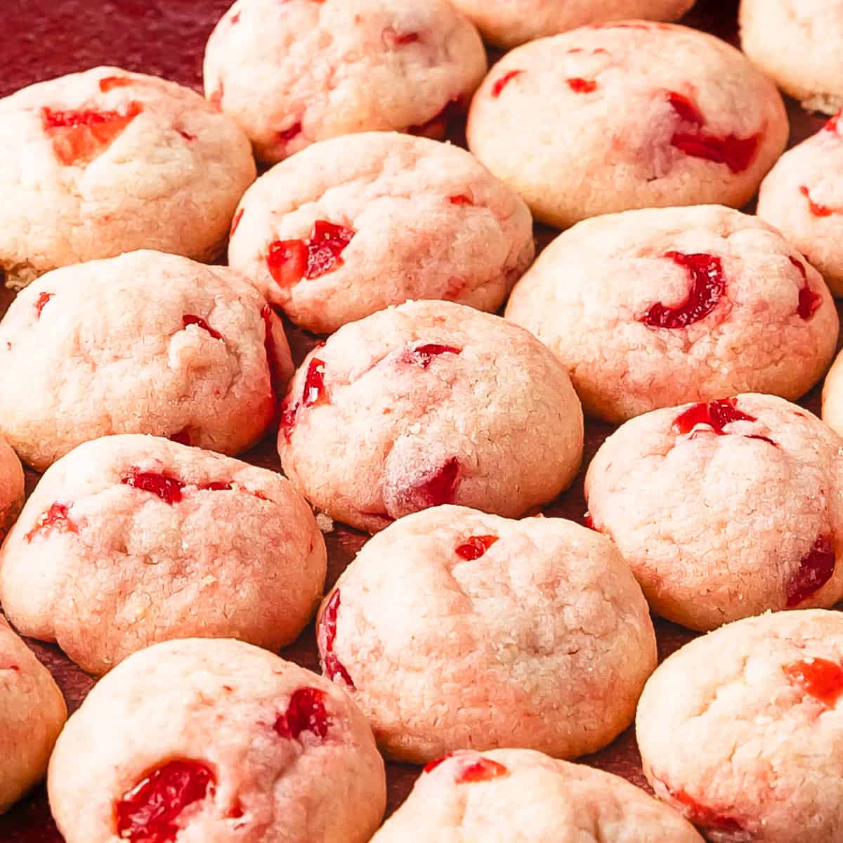 Cherry cookies are soft and buttery shortbread style drop cookies filled with maraschino cherries and sweet almond flavor. These pretty pink maraschino cherry cookies are the perfect quick and easy cherry sugar cookie recipe for any occasion.