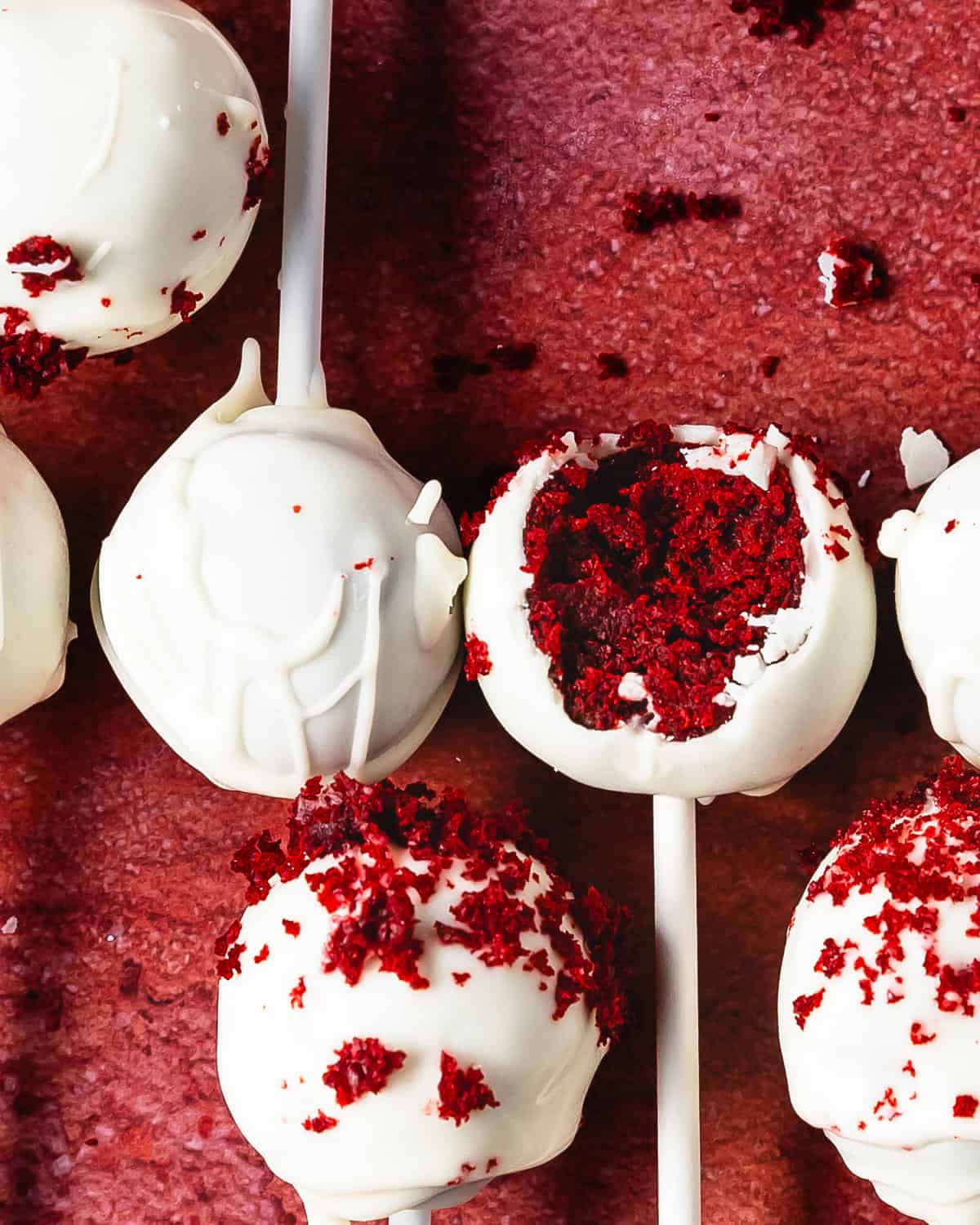 Red velvet cake pops are decadent and delicious red velvet cake balls made from red velvet cake and cream cheese frosting covered in white chocolate. These red velvet truffles are super simple to make using box cake mix, store bought frosting and white chocolate candy melts. 