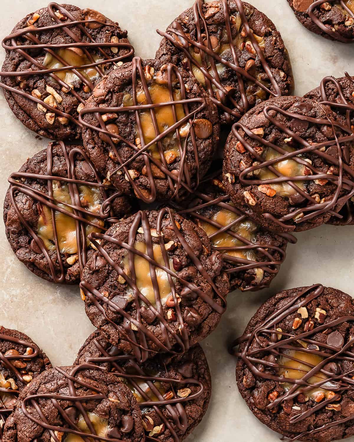 Turtle cookies are soft and chewy chocolate cookies filled with chopped pecans, pockets of melted caramel and gooey chocolate chips. These pecan turtle cookies are topped with more caramel and a drizzle of melted chocolate. Delight everyone with a batch of these easy to make chocolate caramel pecan cookies.