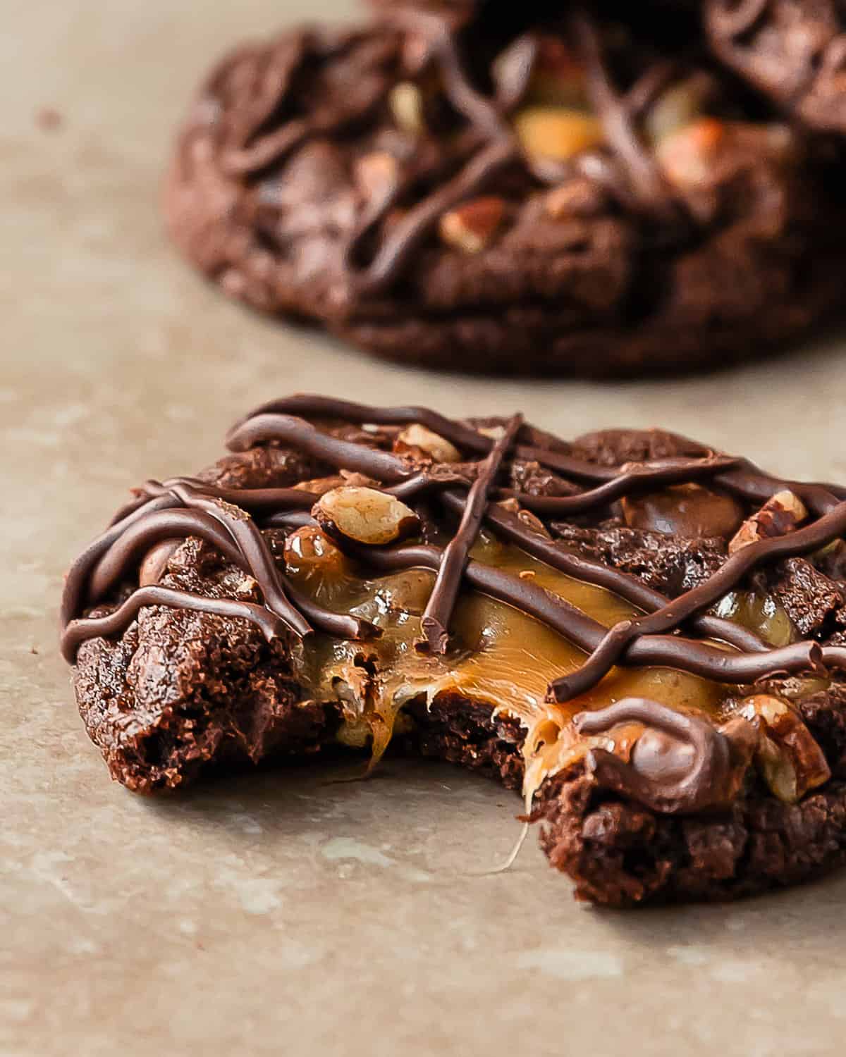 Turtle cookies are soft and chewy chocolate cookies filled with chopped pecans, pockets of melted caramel and gooey chocolate chips. These pecan turtle cookies are topped with more caramel and a drizzle of melted chocolate. Delight everyone with a batch of these easy to make chocolate caramel pecan cookies. 