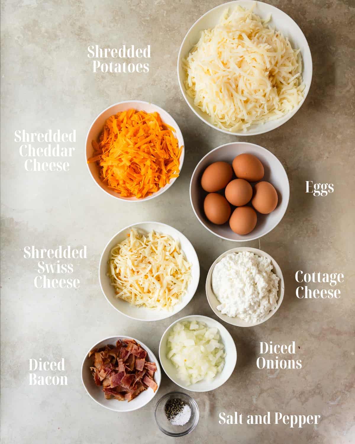 Gather eggs, shredded potatoes, cheddar cheese, swiss cheese, cottage cheese, diced onions, bacon and salt and pepper. 