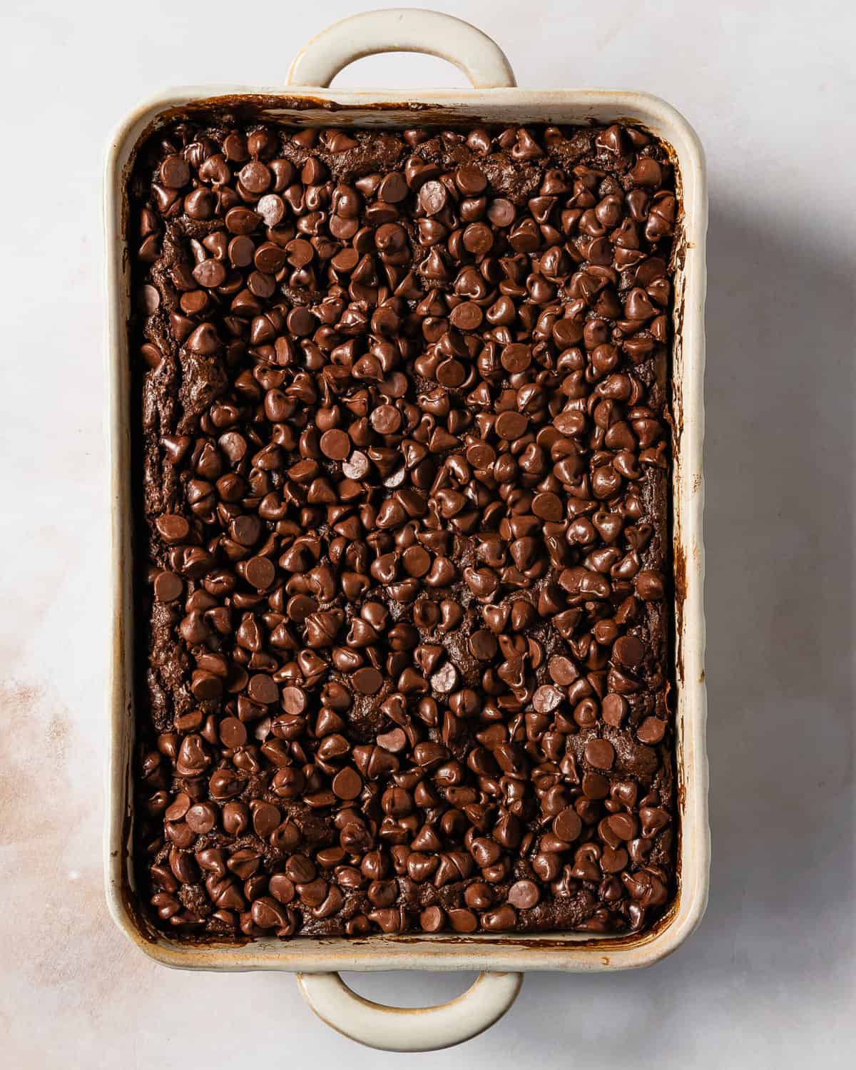 Chocolate dump cake is a quick, easy to make and rich chocolate dessert. This chocolate dump cake recipe is made from moist chocolate cake mix, creamy chocolate pudding and sweet chocolate chips. Top this decadent chocolate pudding dump cake with cold vanilla ice cream for the perfect dessert.