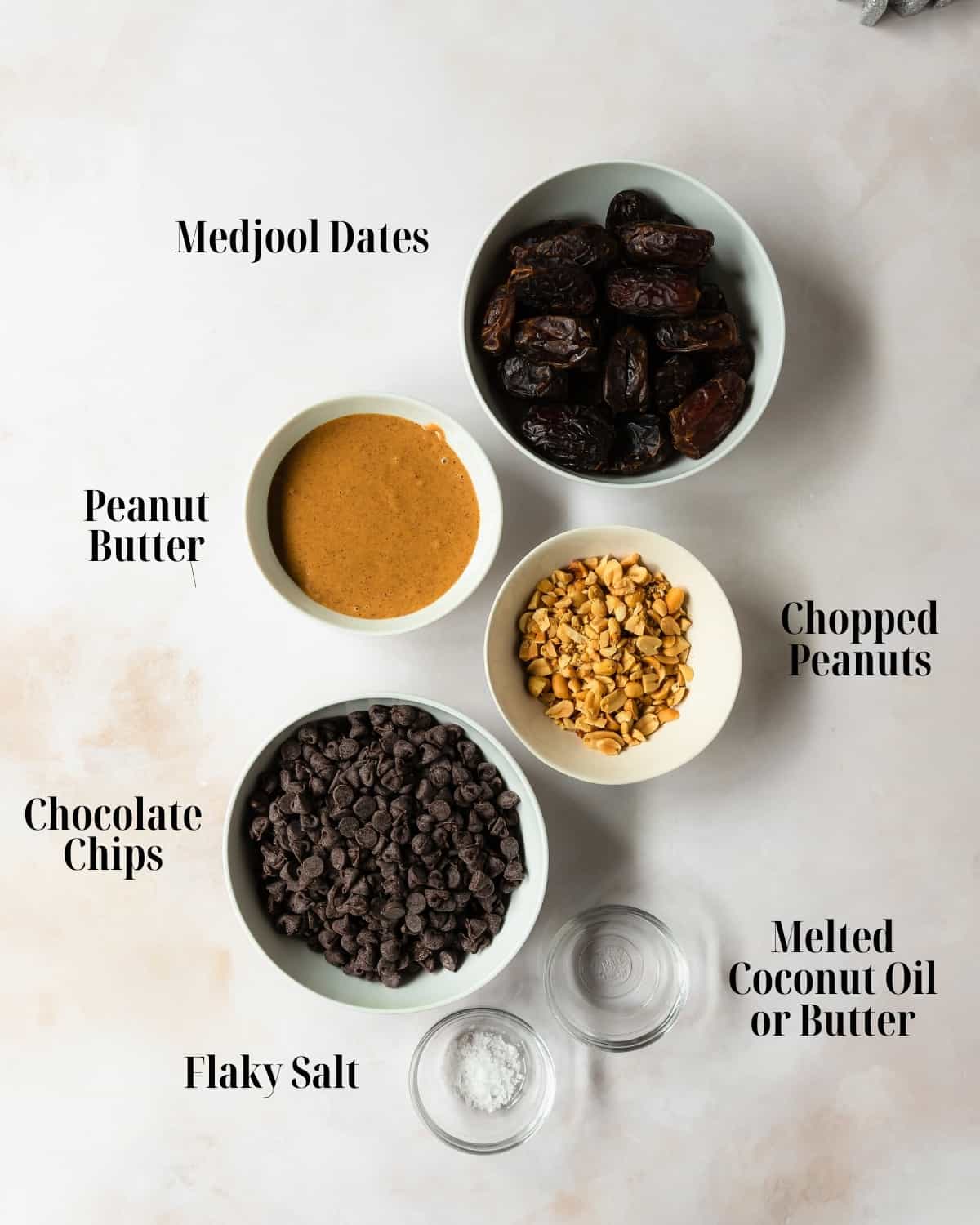 Gather Medjool dates, peanut butter, chopped peanuts, your choice of chocolate chips or chunks, coconut oil (optional) and flaky salt (optional).  