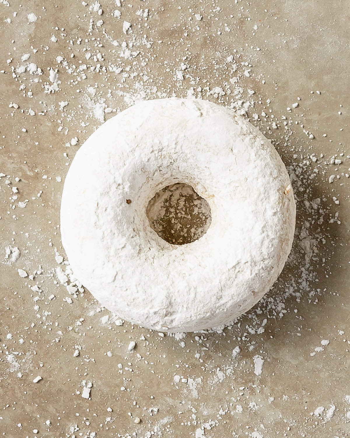 Powdered sugar donuts are soft, moist and fluffy, lightly spiced baked donuts coated in powdered sugar. These cake-style powdered donuts are quick and easy to make using two bowls, a whisk and a donut pan. If you can make muffins, you can make these cozy powder sugar donuts. 