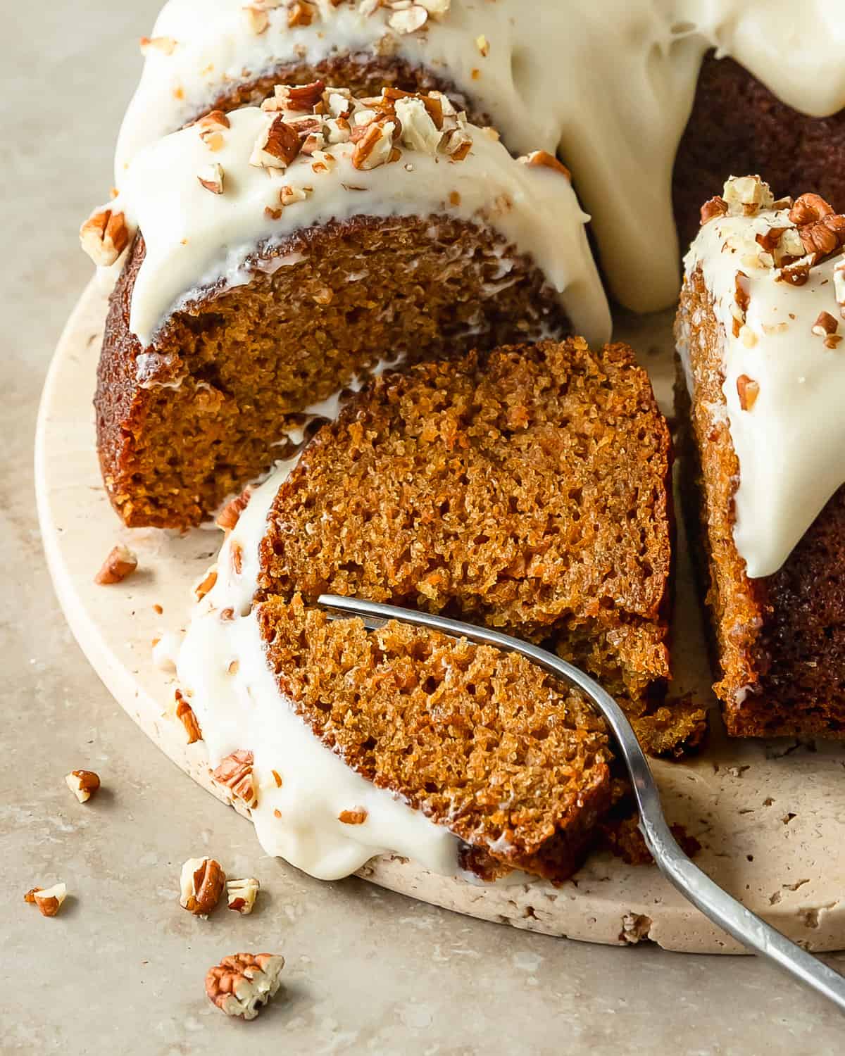 Carrot bundt cake is a perfectly moist carrot cake filled with freshly grated carrots and a blend of classic warming spices. Top this bundt carrot cake with a rich and tangy cream cheese glaze and crunchy pecans.  With its beautiful bakery worthy appearance and easy preparation, this carrot cake bundt cake is the perfect cake for all your holiday gatherings. 