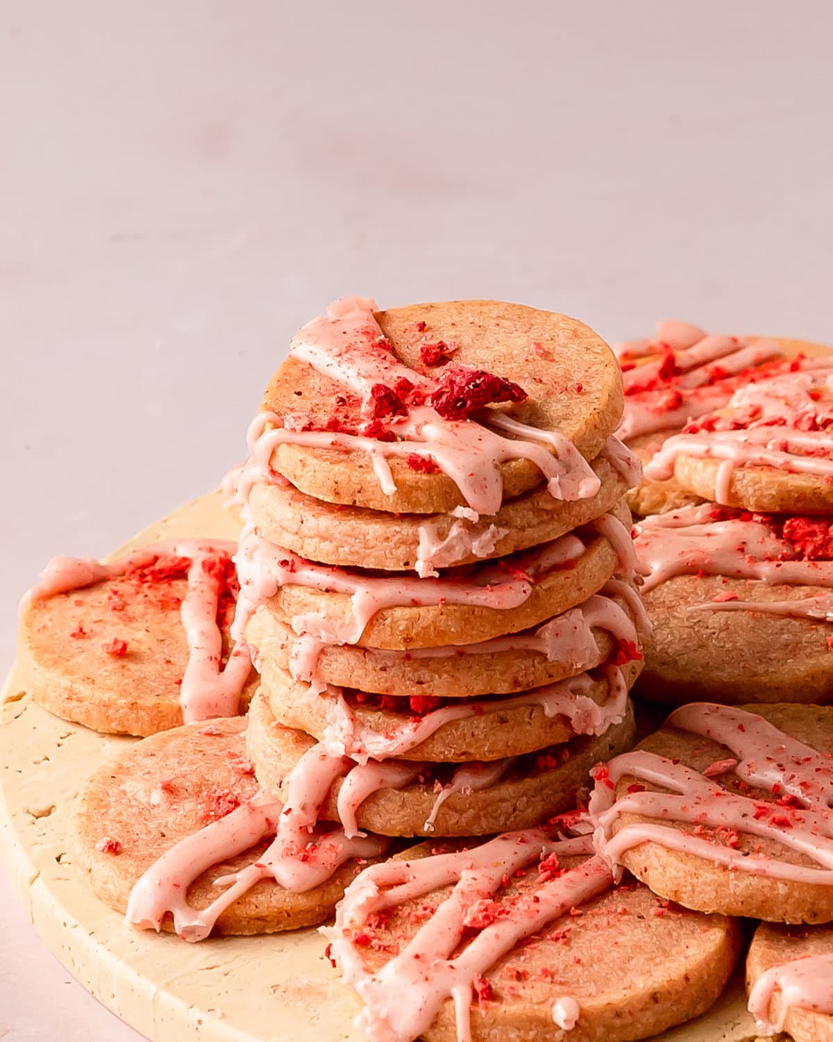 Strawberry shortbread cookies are buttery shortbread cookies filled with sweet and tart strawberry flavor. These strawberry butter cookies get their pink hue and berry flavor thanks to freeze dried strawberries in both the cookie and glaze. Make these pink shortbread cookies for a taste of spring and summer all year long.