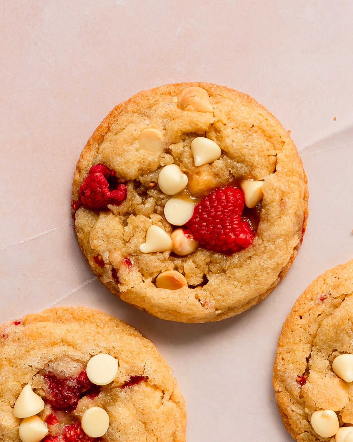 White chocolate raspberry cookies are soft, chewy and buttery sugar cookies filled with tart, juicy raspberries and creamy white chocolate. This raspberry white chocolate cookie recipe is no chill, quick and easy to make in one bowl.