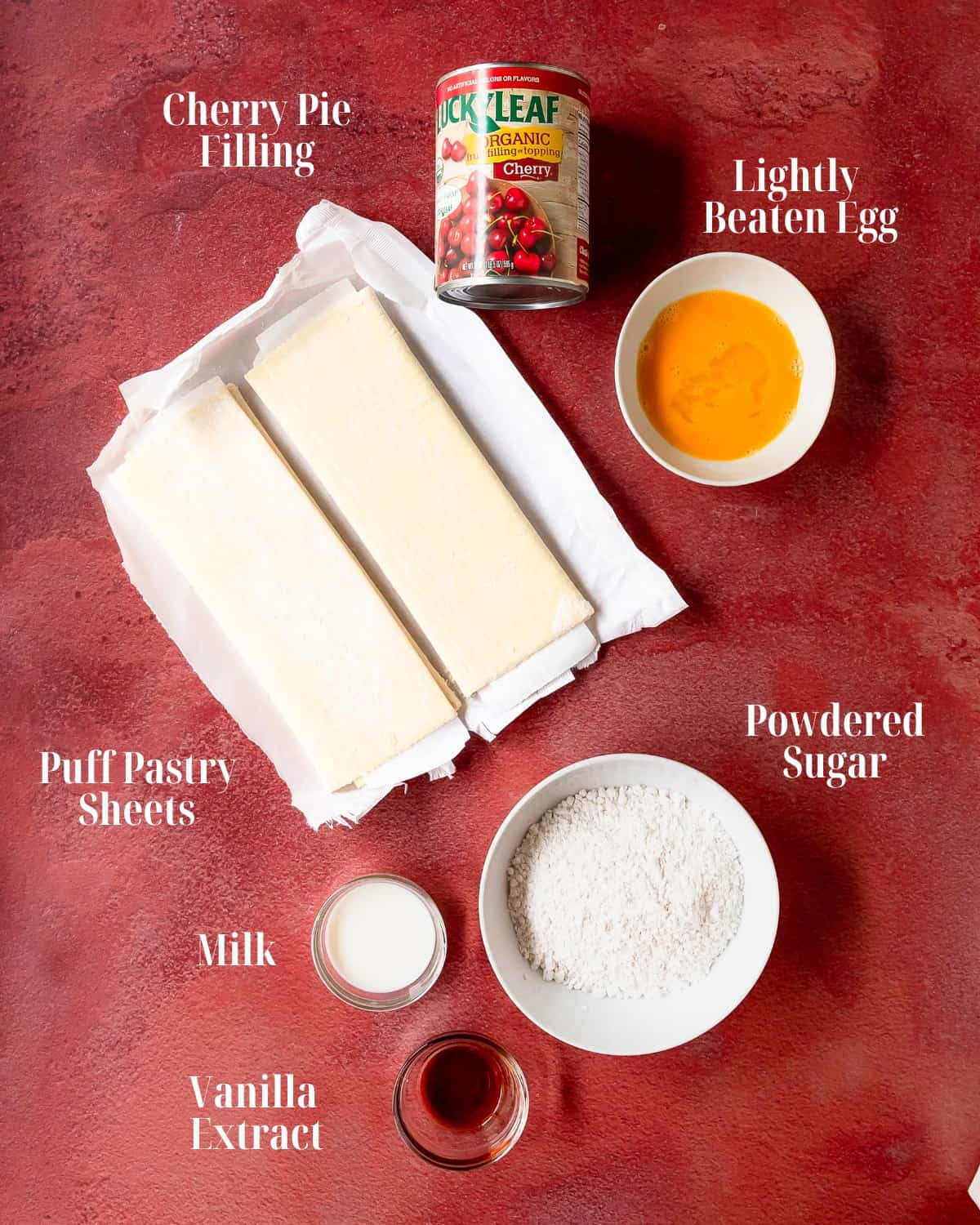 Gather store bought or homemade puff pastry sheets, cherry pie filling, an egg and sugar for topping. For the vanilla glaze, gather powdered sugar, milk and vanilla extract. 
