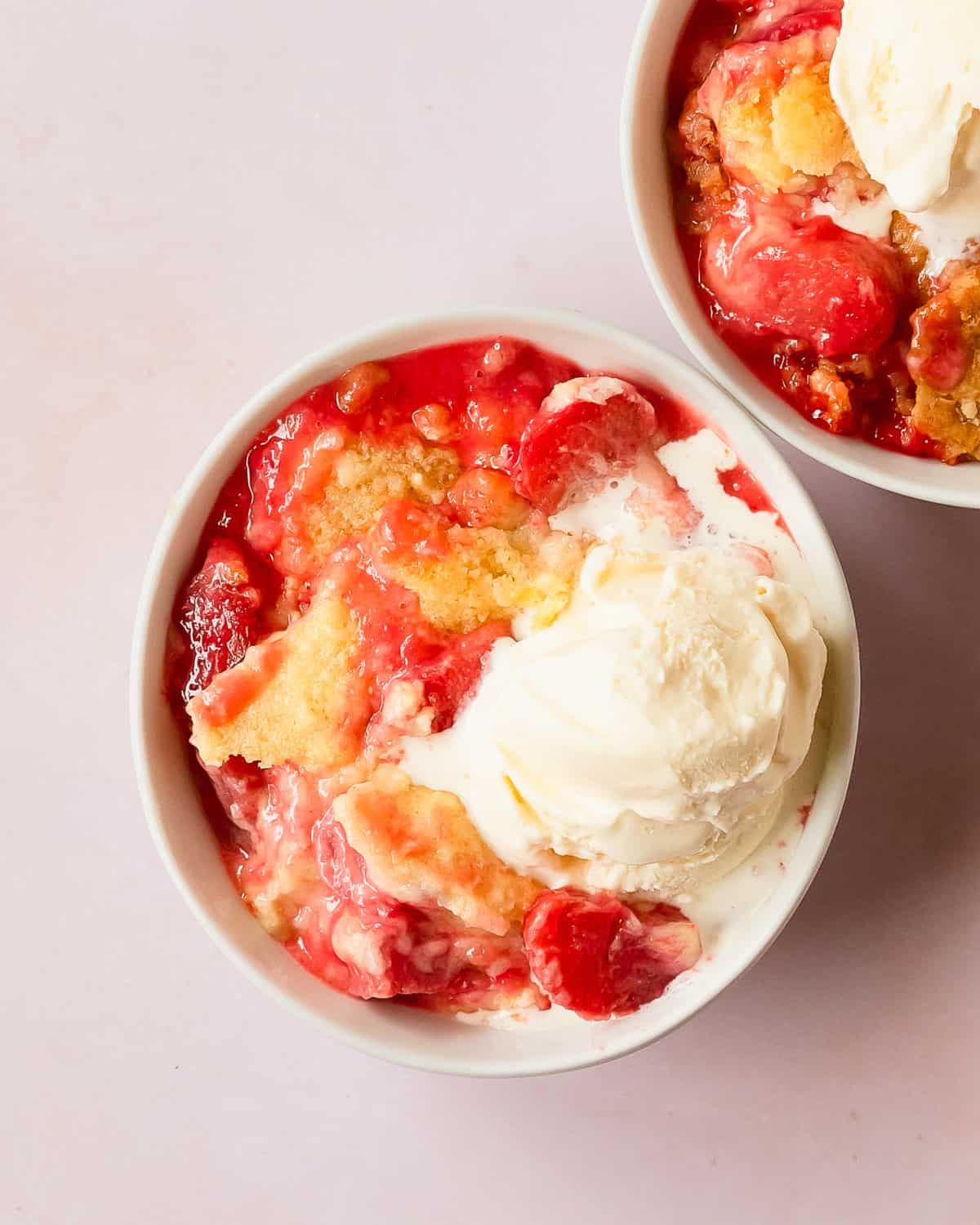 Rhubarb dump cake is a refreshingly delicious baked fruit dessert made from tart rhubarb, sweet strawberry jello, white or yellow cake mix and butter. Make this rhubarb cake mix cobbler for the perfect quick and easy spring or summer dessert.