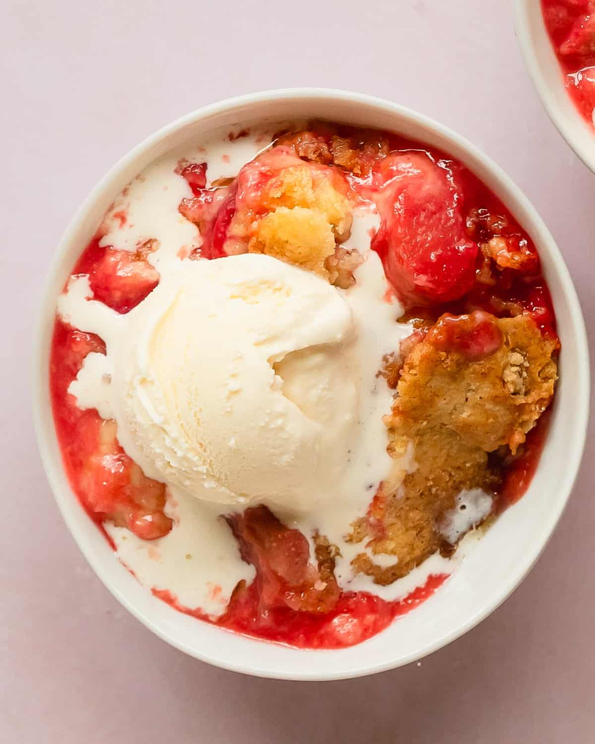 Rhubarb dump cake is a refreshingly delicious baked fruit dessert made from tart rhubarb, sweet strawberry jello, white or yellow cake mix and butter. Make this rhubarb cake mix cobbler for the perfect quick and easy spring or summer dessert.