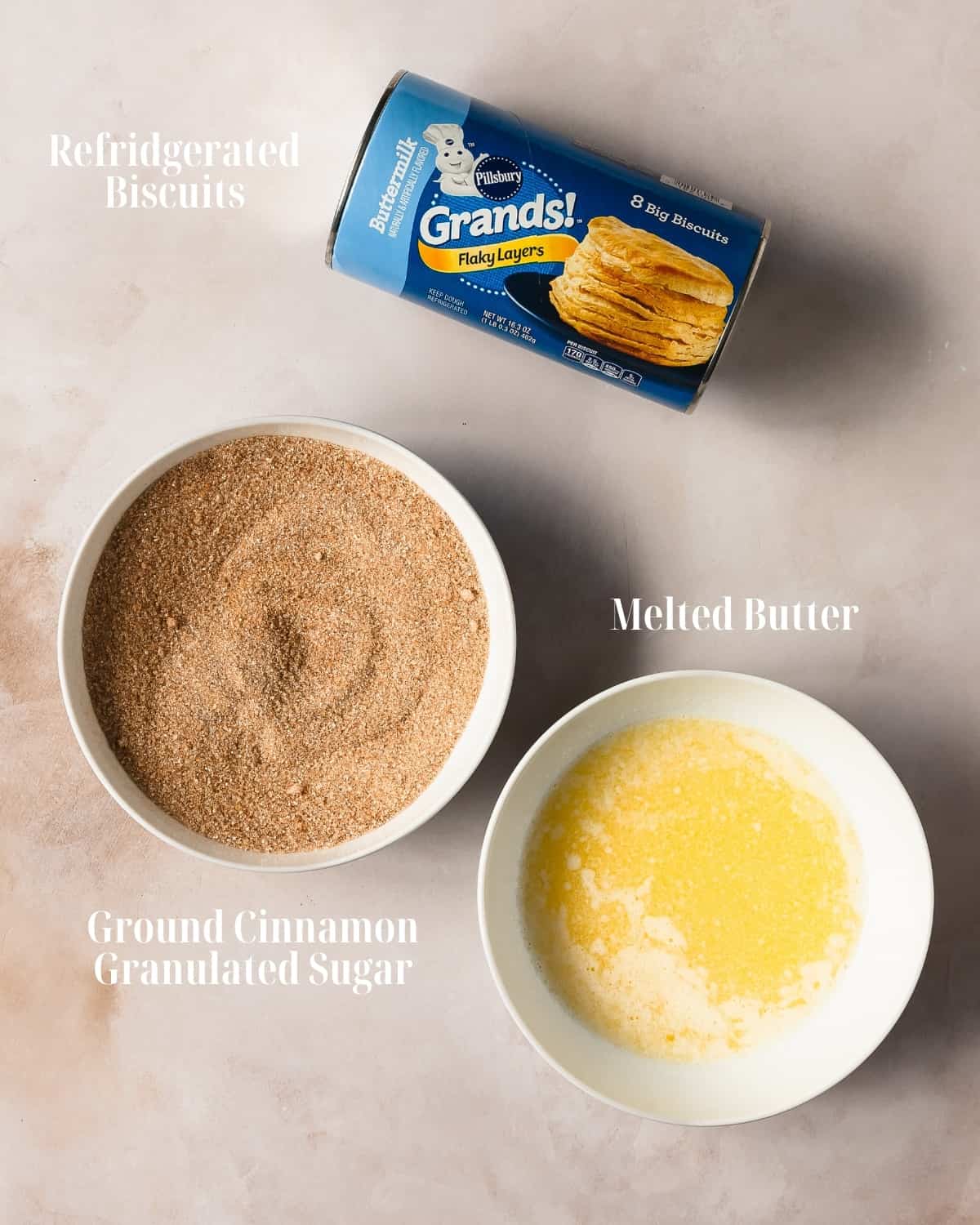 Gather refrigerated canned biscuit dough. To top the biscuit donuts as written for this recipe, gather melted butter, ground cinnamon and sugar. 