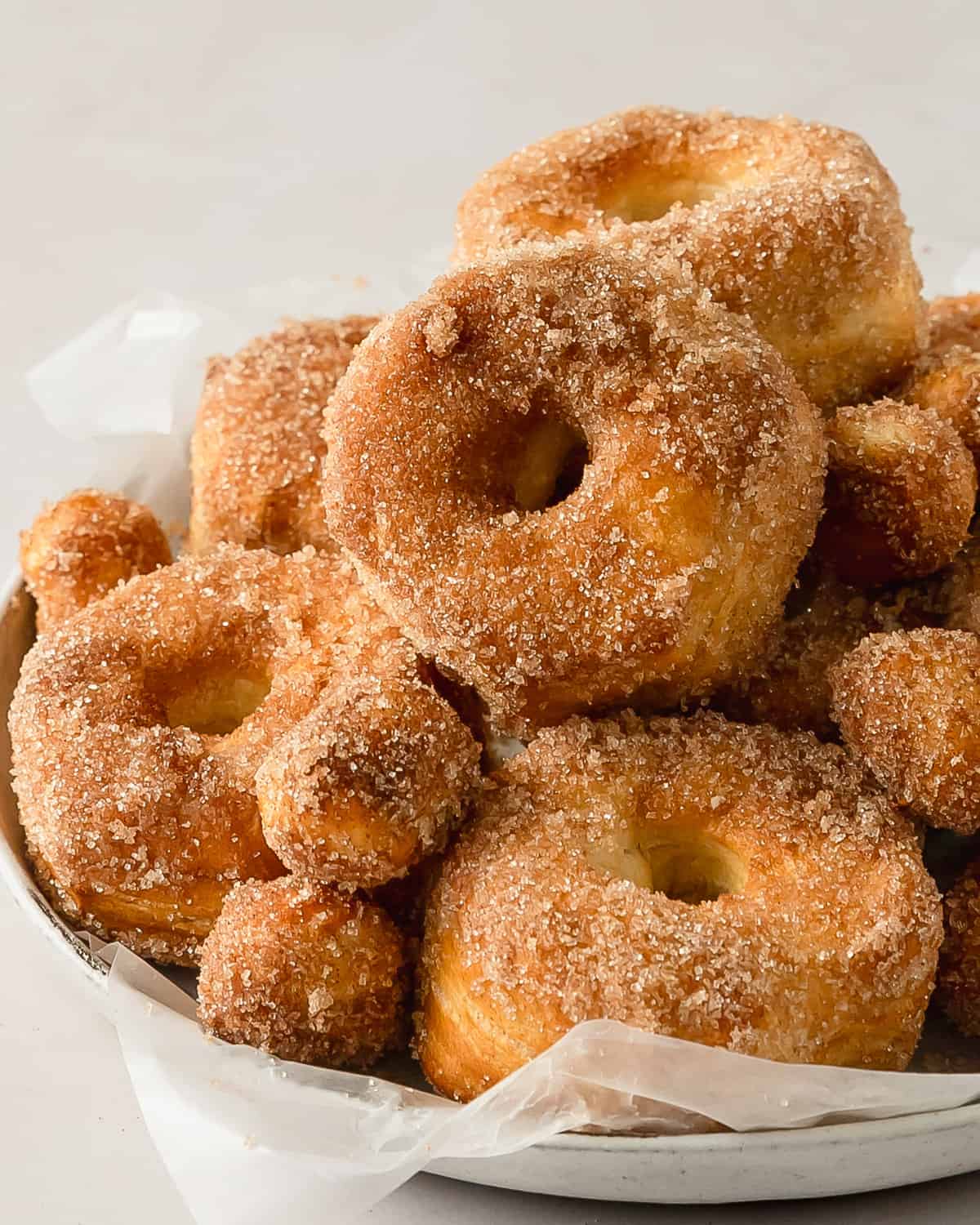 Air fryer biscuit donuts are flaky and fluffy air fryer donuts made using store bought, refrigerated biscuit dough. These easy to make biscuit doughnuts are dipped in melted butter and covered in a sweet and crunchy cinnamon sugar coating. Prep and air fryer these cinnamon sugar biscuit donuts in under 10 minutes. 