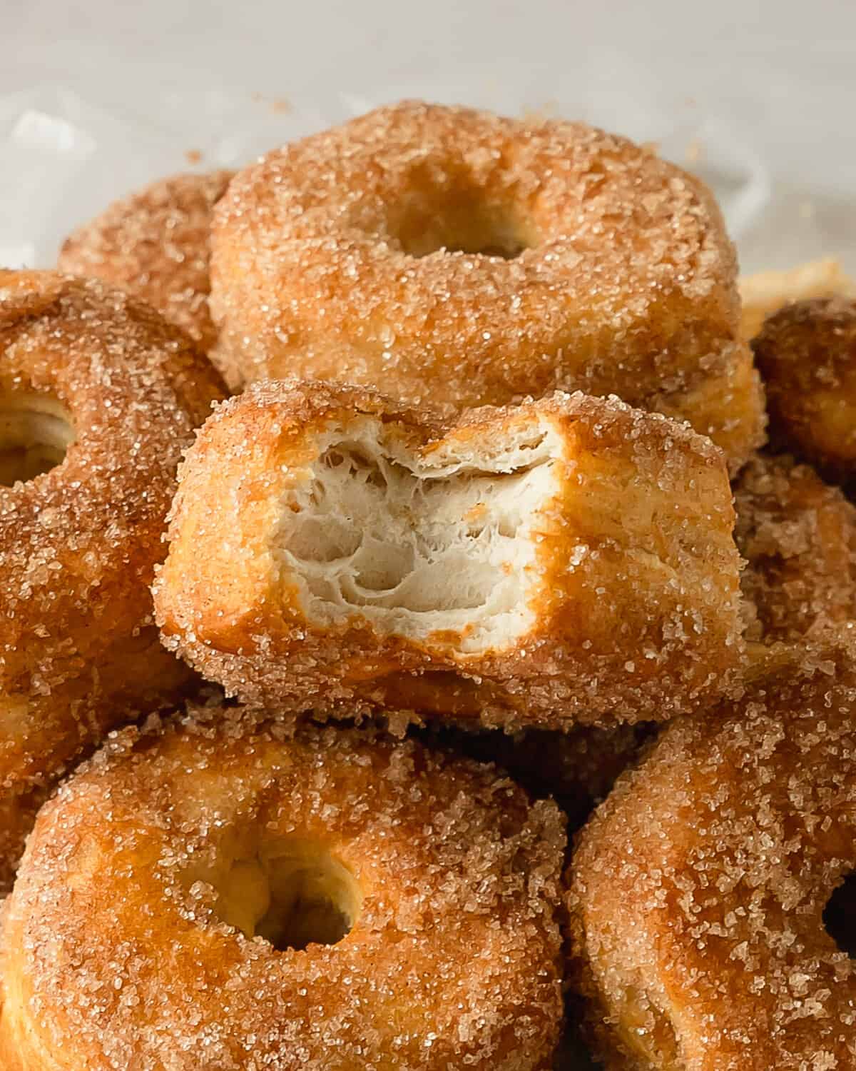 Air fryer biscuit donuts are flaky and fluffy air fryer donuts made using store bought, refrigerated biscuit dough. These easy to make biscuit doughnuts are dipped in melted butter and covered in a sweet and crunchy cinnamon sugar coating. Prep and air fryer these cinnamon sugar biscuit donuts in under 10 minutes. 