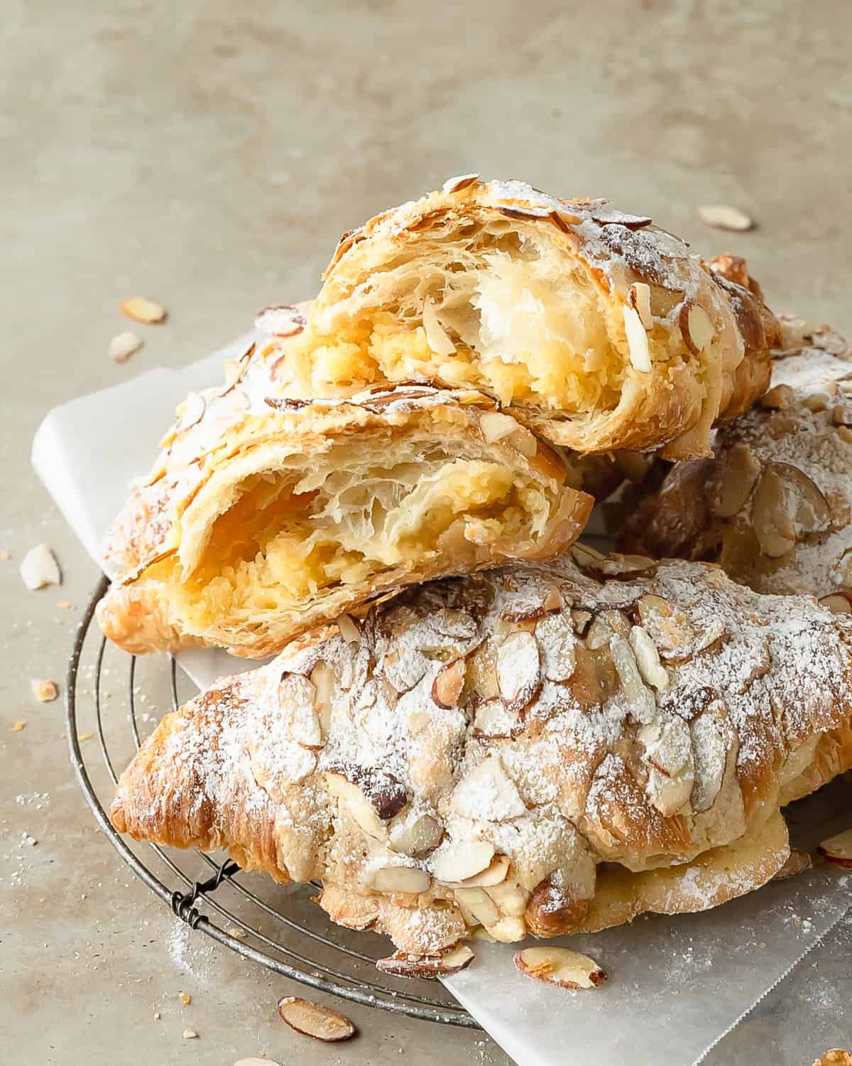 Almond croissants are an easy to make version of the classic french pastry, croissants aux amandes. This quick almond croissant recipe uses day old store bought croissants, filled with a homemade almond pastry cream, topped with a sweet almond syrup. Skip the fancy french bakery and make these buttery almond filled croissants for the perfect breakfast or brunch treat.