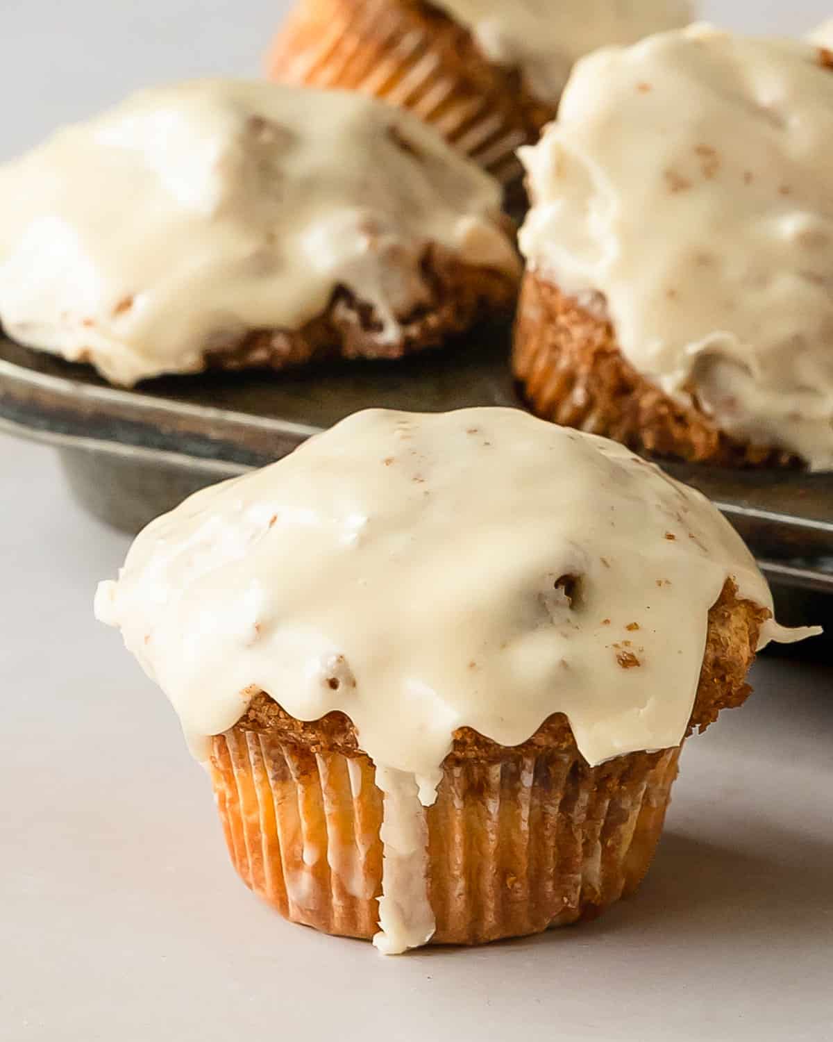 Cinnamon roll muffins are wonderfully soft, light and fluffy no yeast muffins filled with ribbons of sweet cinnamon roll filling.  Once baked, these cute cinnamon rolls muffins are topped with a sweet and tangy cream cheese glaze. These cinnamon bun muffins are quick, easy to make and muffins are perfect for breakfasts or snacks. 