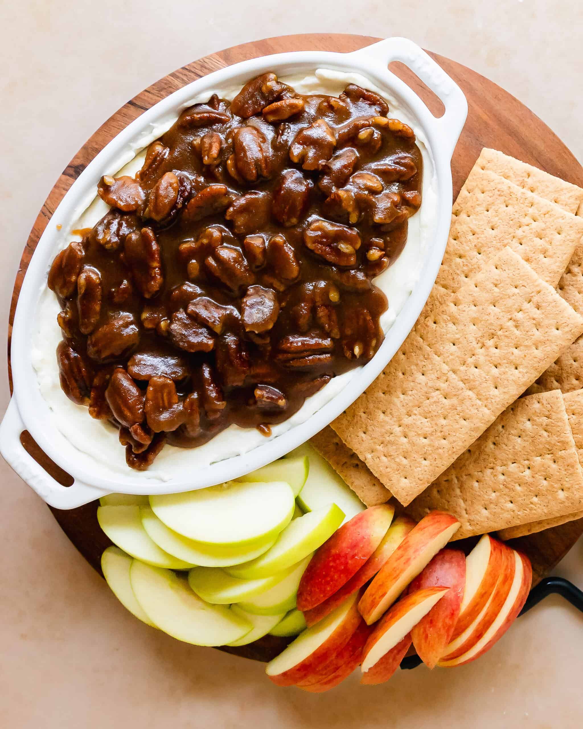 Pecan pie dip is a rich and creamy no bake cheesecake dip topped with gooey and crunchy pecan pie filling. This pecan pie dip recipe is quick and easy to make. It’s the perfect dessert dip to serve with apples, cookies, crackers or pretzels.