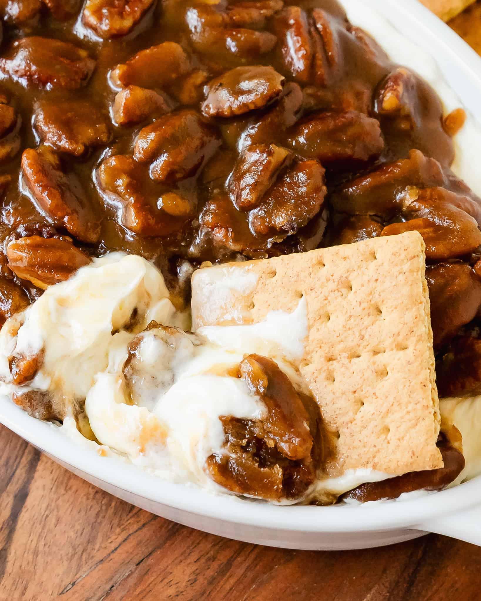 Pecan pie dip is a rich and creamy no bake cheesecake dip topped with gooey and crunchy pecan pie filling. This pecan pie dip recipe is quick and easy to make. It’s the perfect dessert dip to serve with apples, cookies, crackers or pretzels.