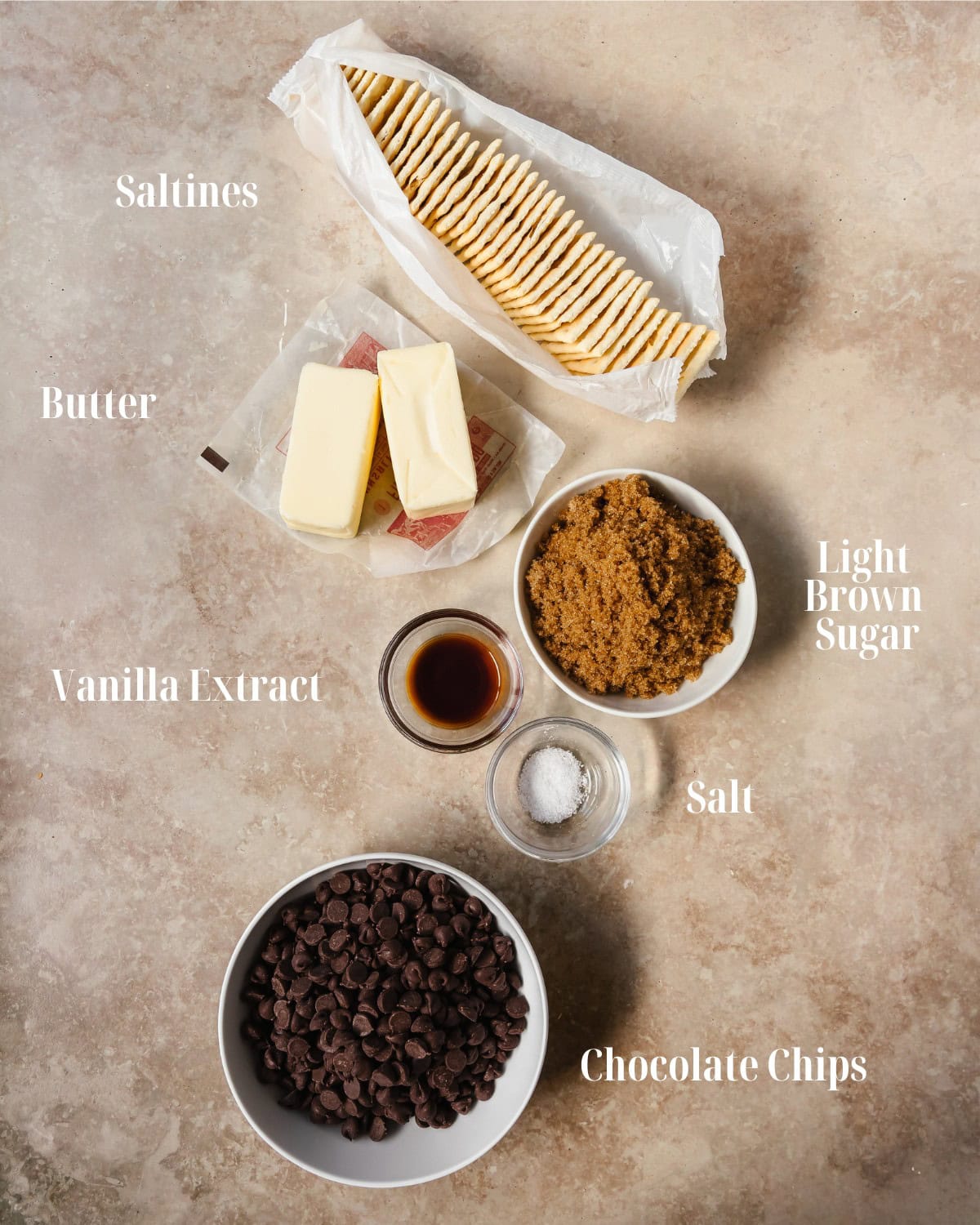Gather saltine crackers, light brown sugar, butter, vanilla extract, salt and your preferred toppings. The topping pictured is Heath toffee bits.