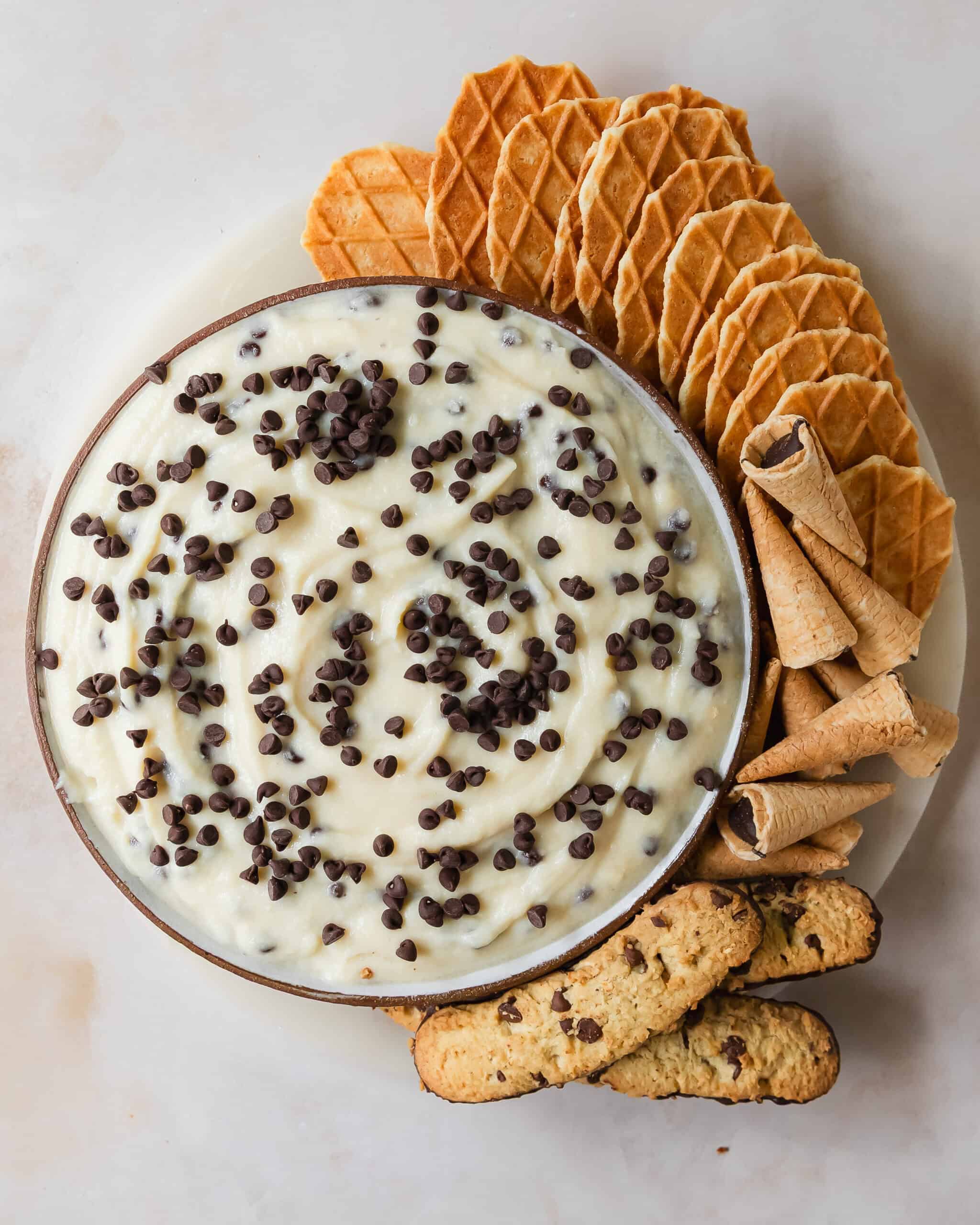 Cannoli dip is a rich and creamy, no bake dessert dip made with ricotta cheese, mascarpone or cream cheese and mini chocolate chips. This cannoli dip recipe is quick, easy to make and makes the best sweet dip for your favorite holiday treats.