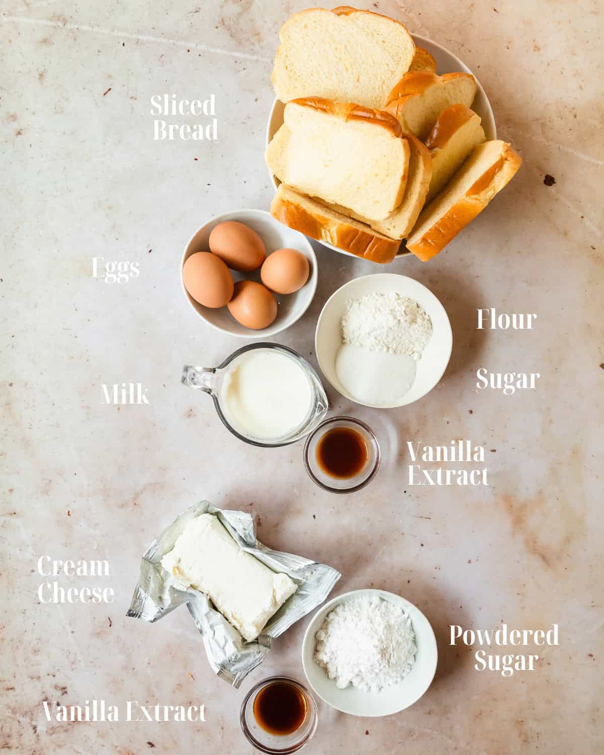 Gather stale or day old slices of buttery bread, cream cheese, powdered sugar, eggs, milk, sugar, flour, vanilla extract, cinnamon and butter for cooking. To serve the cream cheese french toast as shown in the recipe, gather powdered sugar, freshly whipped cream, maple syrup and fresh strawberries.