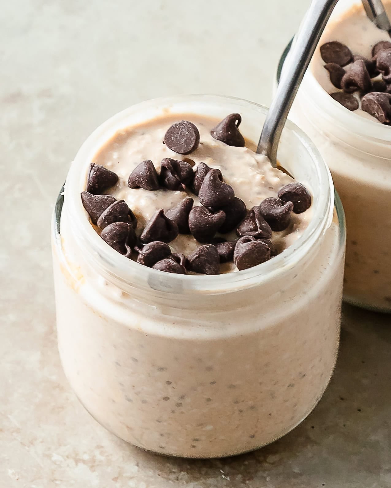 Cookie dough overnight oats is a rich and creamy make ahead breakfast or snack made by soaking rolled oats overnight in a sweetened milk and yogurt mixture. Mix in chia seeds, protein powder, nut butter and chocolate chips for a cookie dough oatmeal thats healthy, filled with protein and tastes like cookie dough.