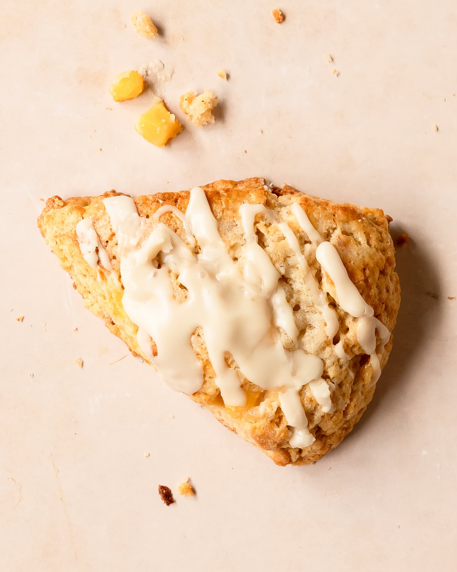 Peach scones with a crumbly texture and vanilla glaze drizzle.