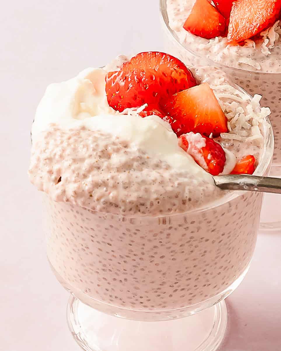 Thick and creamy strawberry chia pudding served in a glass with fresh fruit garnish.