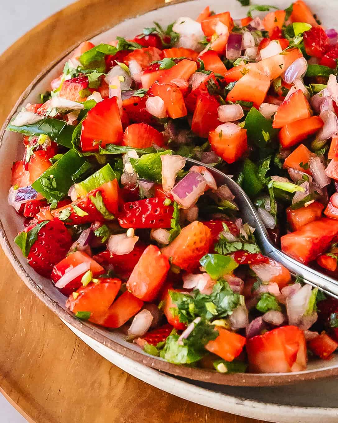 Close-up of strawberry salsa served in a bowl with a spoon.