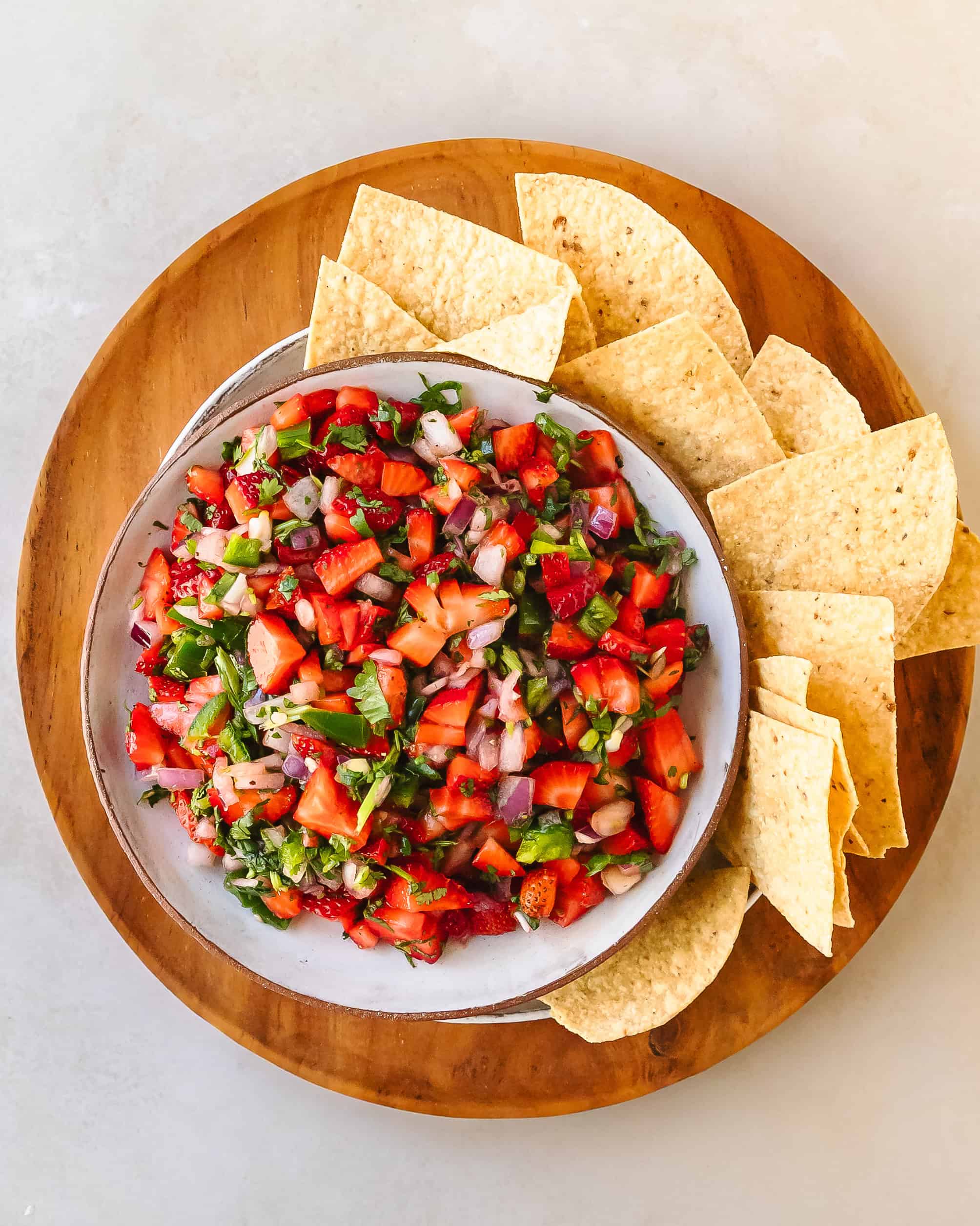 Bright bowl of fresh strawberry salsa with diced strawberries, red onion, cilantro, and jalapeño mixed together.