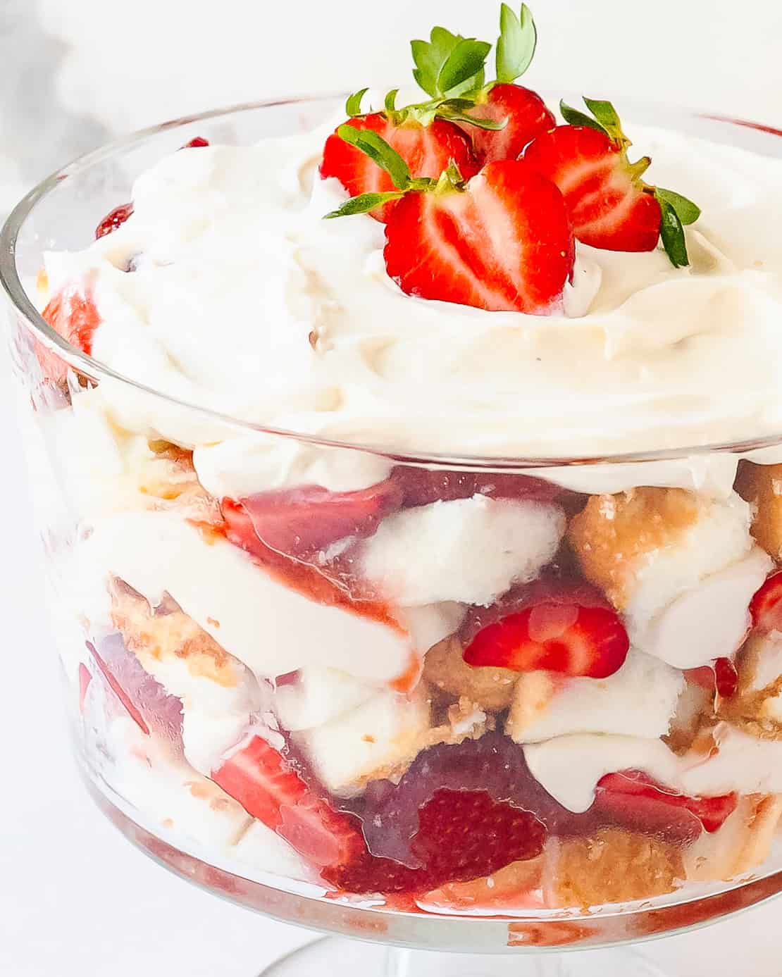Close-up of strawberry trifle layers with cake, cream and fresh strawberries.