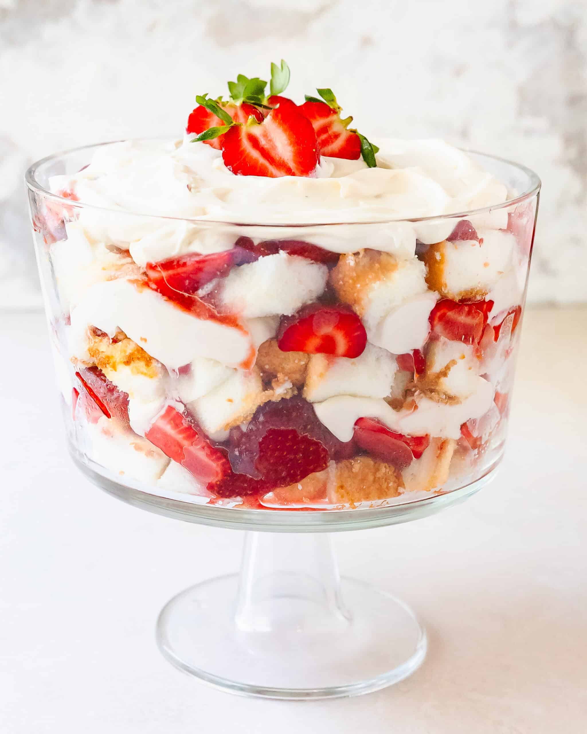 Close-up of strawberry trifle layers with cake, cream and fresh berries