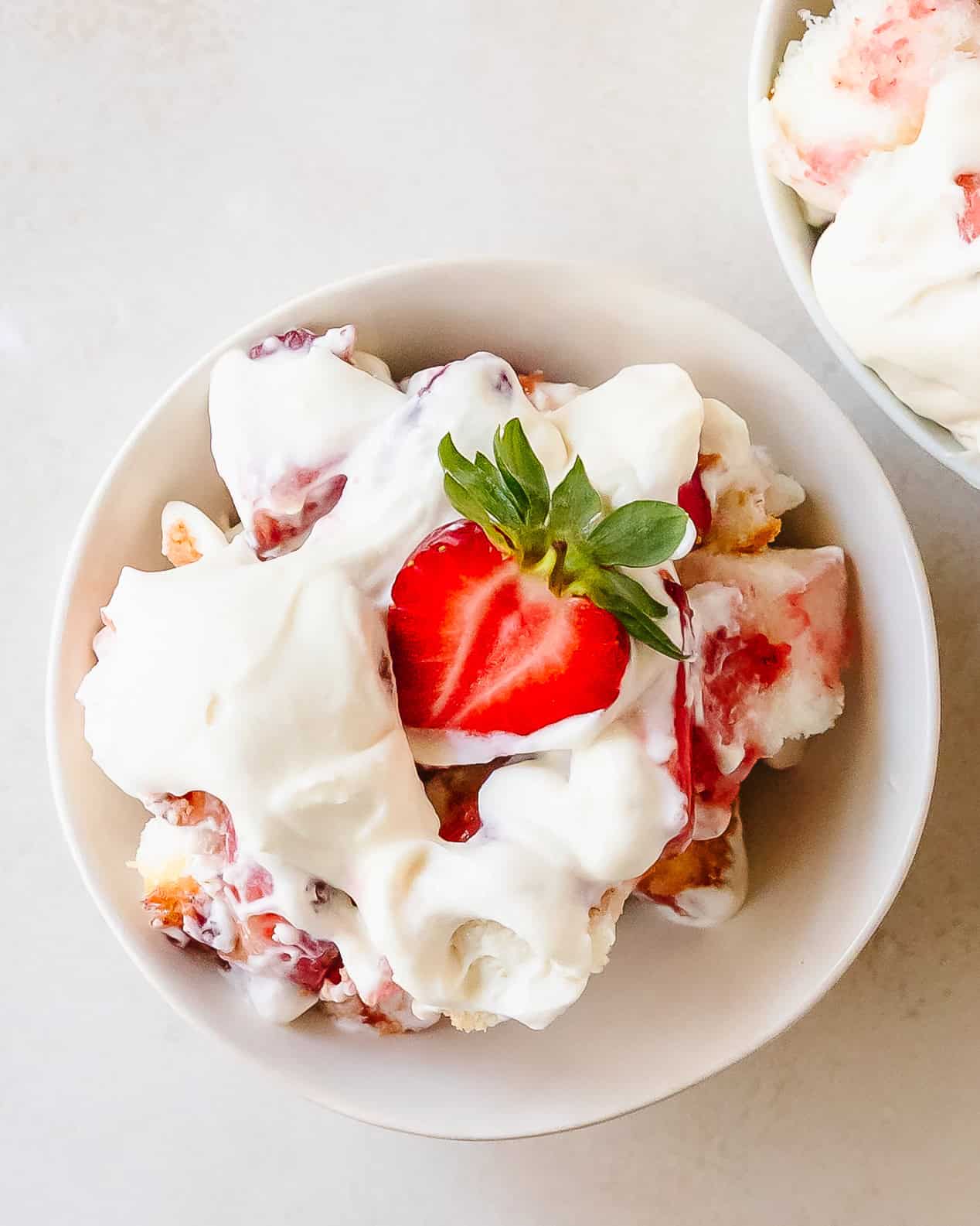 Layered strawberry shortcake trifle in bowl.
