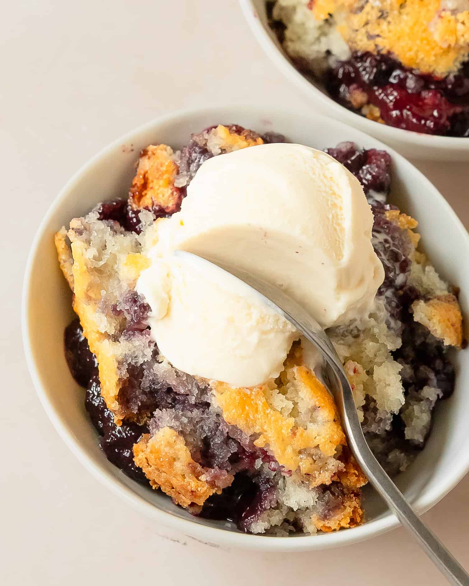 Homemade blackberry cobbler topped with melting vanilla ice cream