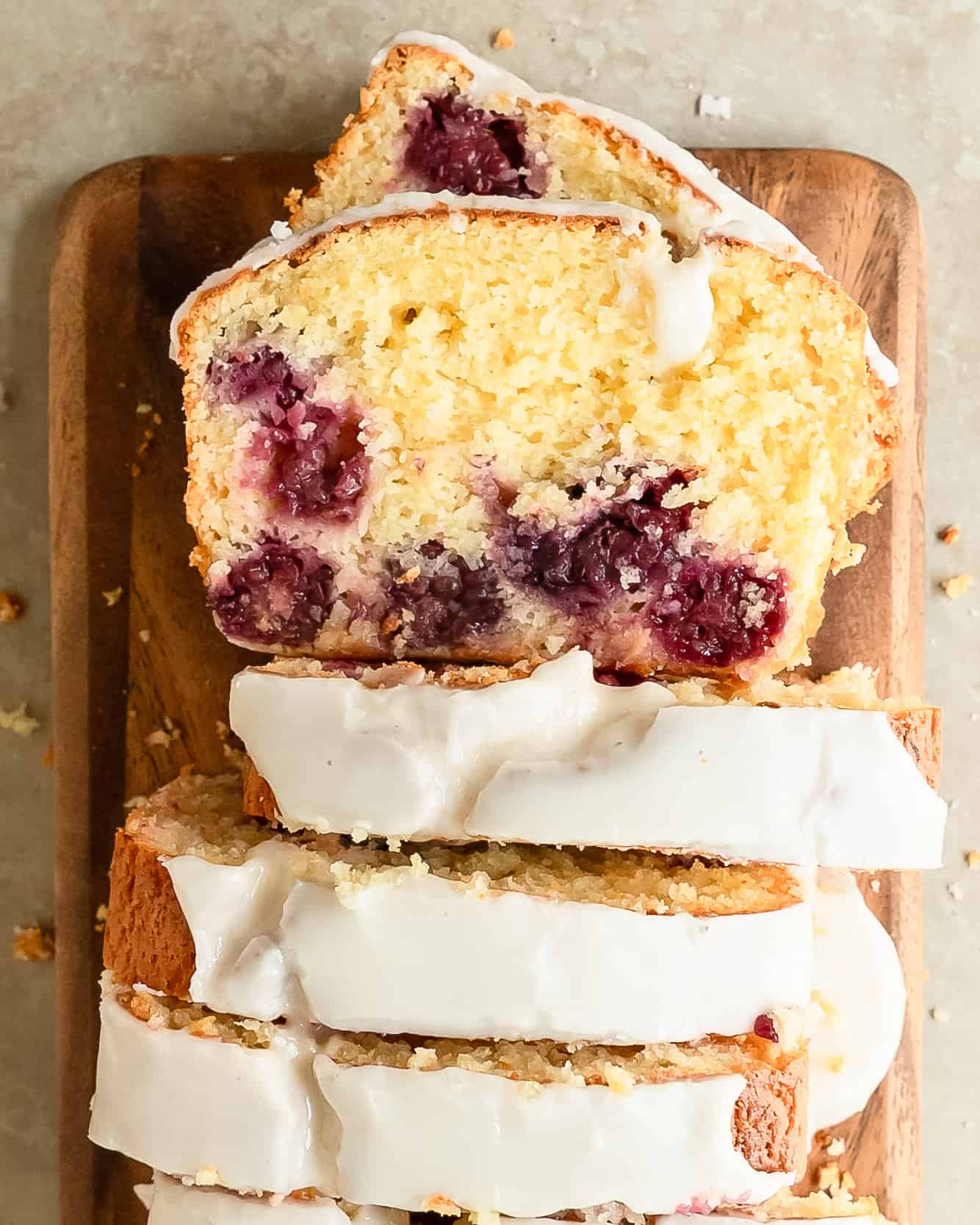 Close-up of a lemon blackberry loaf showcasing its soft texture, vibrant berries, and citrus glaze.